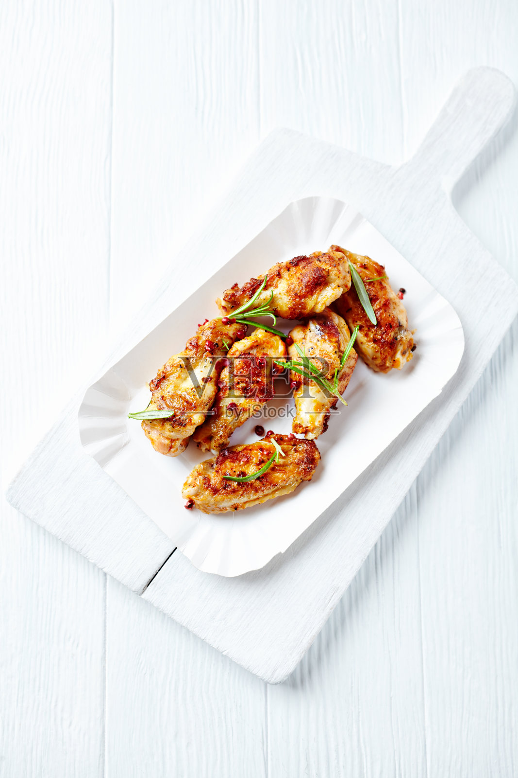 鲜迷迭香烤鸡翅，明亮的木制背景。前视图。照片摄影图片