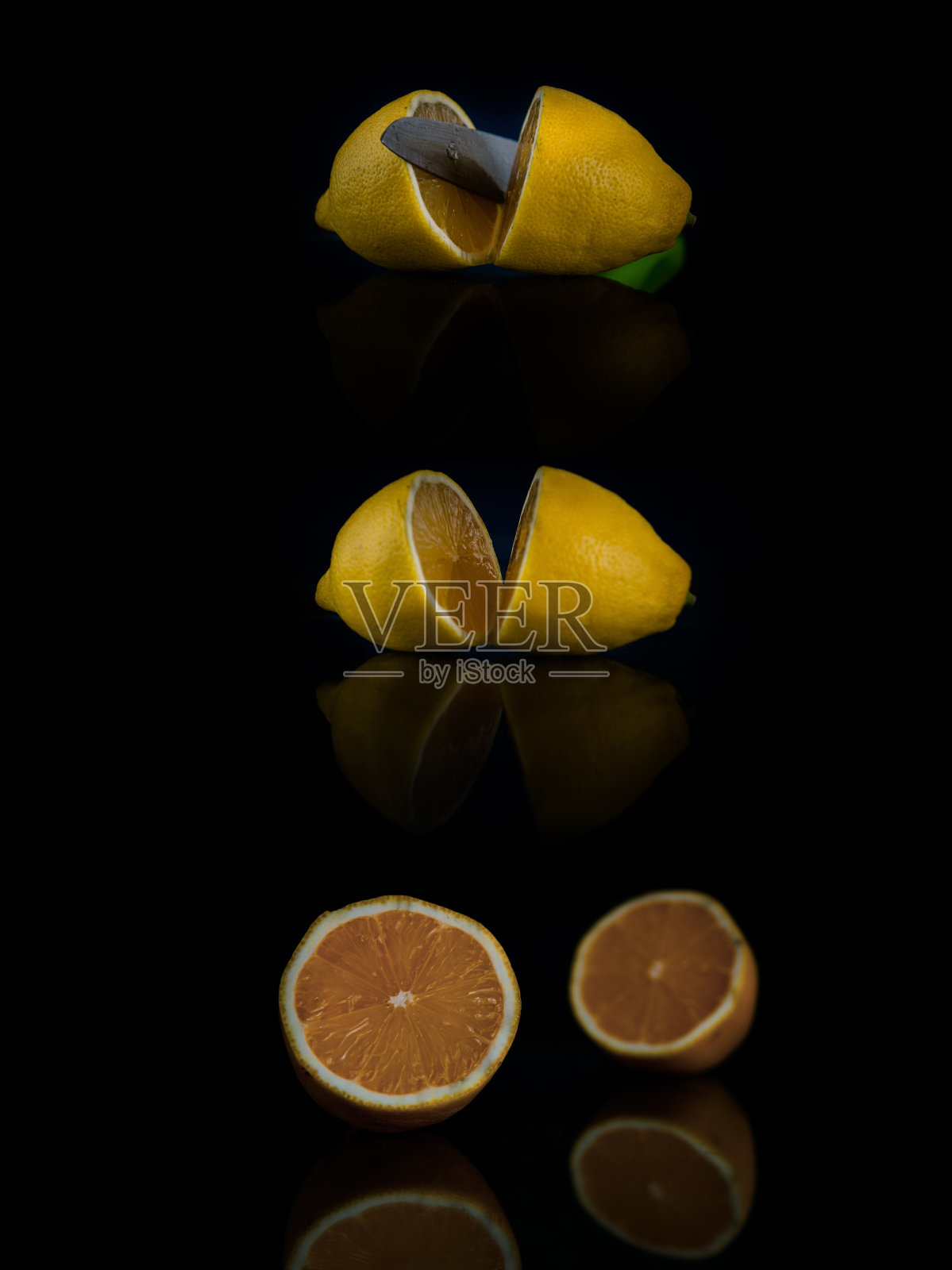 用小刀将切成两半的柠檬拼贴在黑色背景上照片摄影图片
