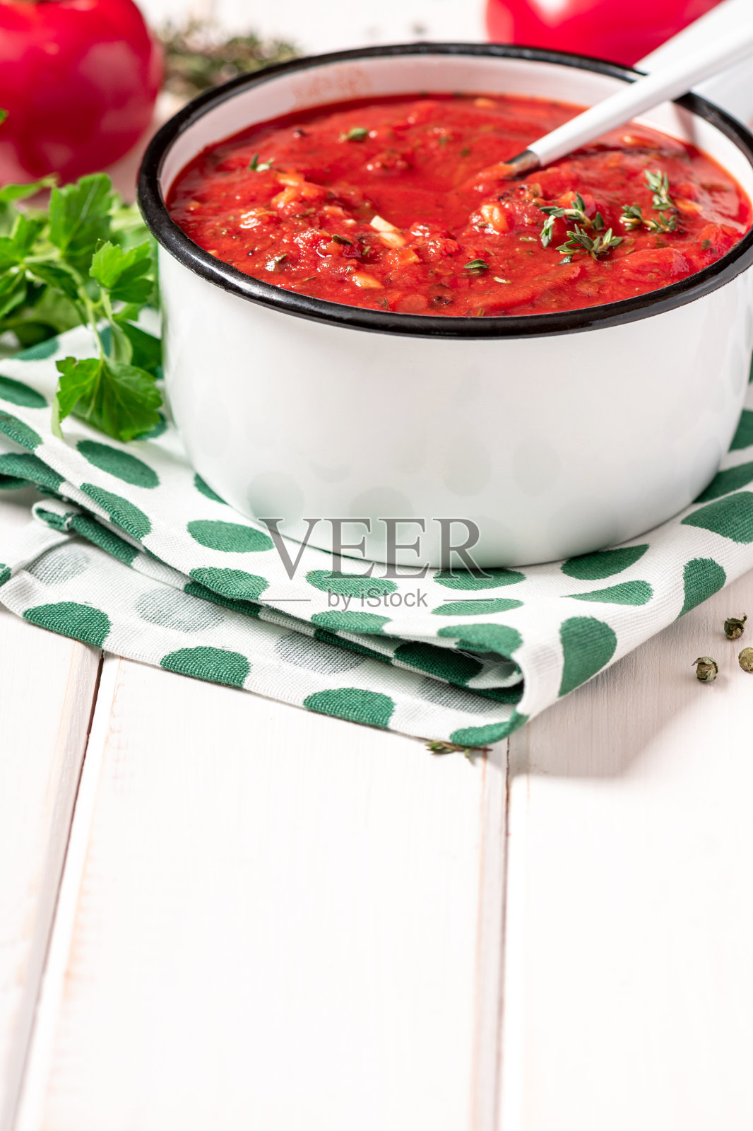 在白锅里放上自制的辣味番茄酱、香草和大蒜照片摄影图片