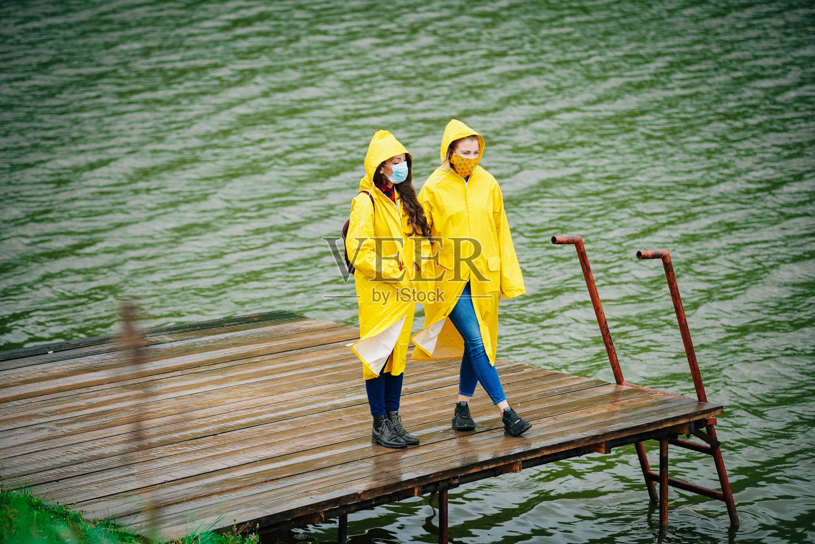 两个女人穿着雨衣和防护面具照片摄影图片