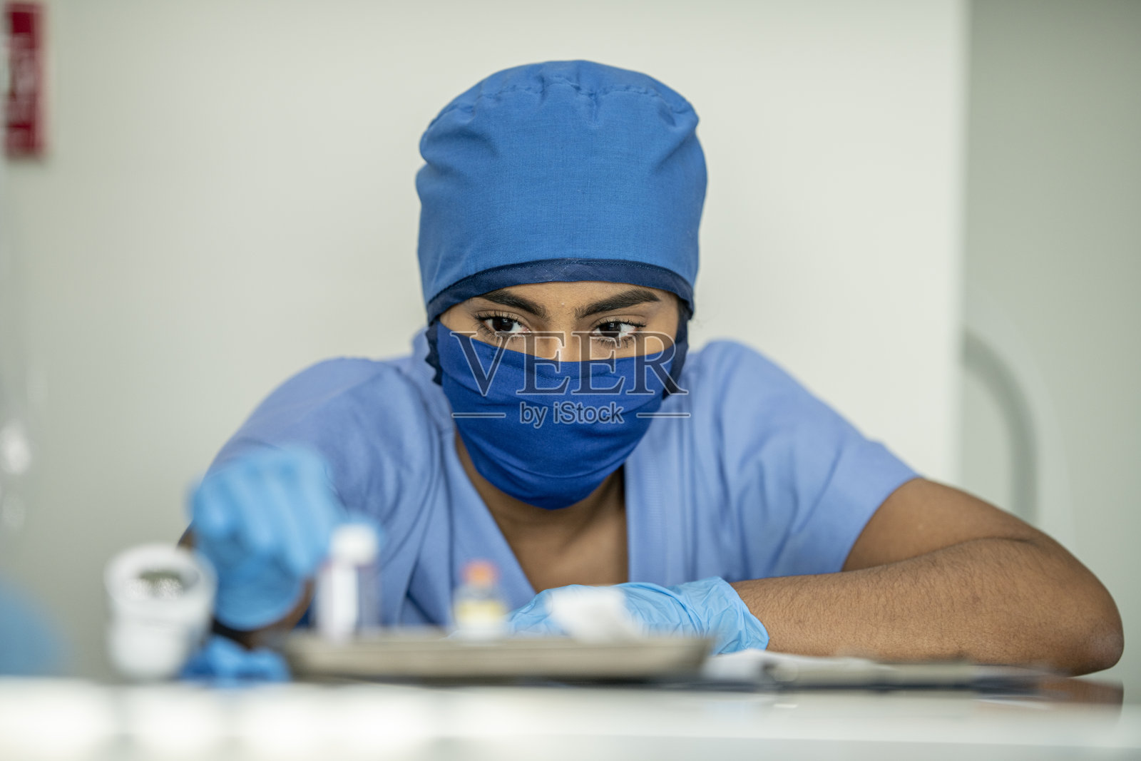 少数民族医生倾身检查药瓶照片摄影图片