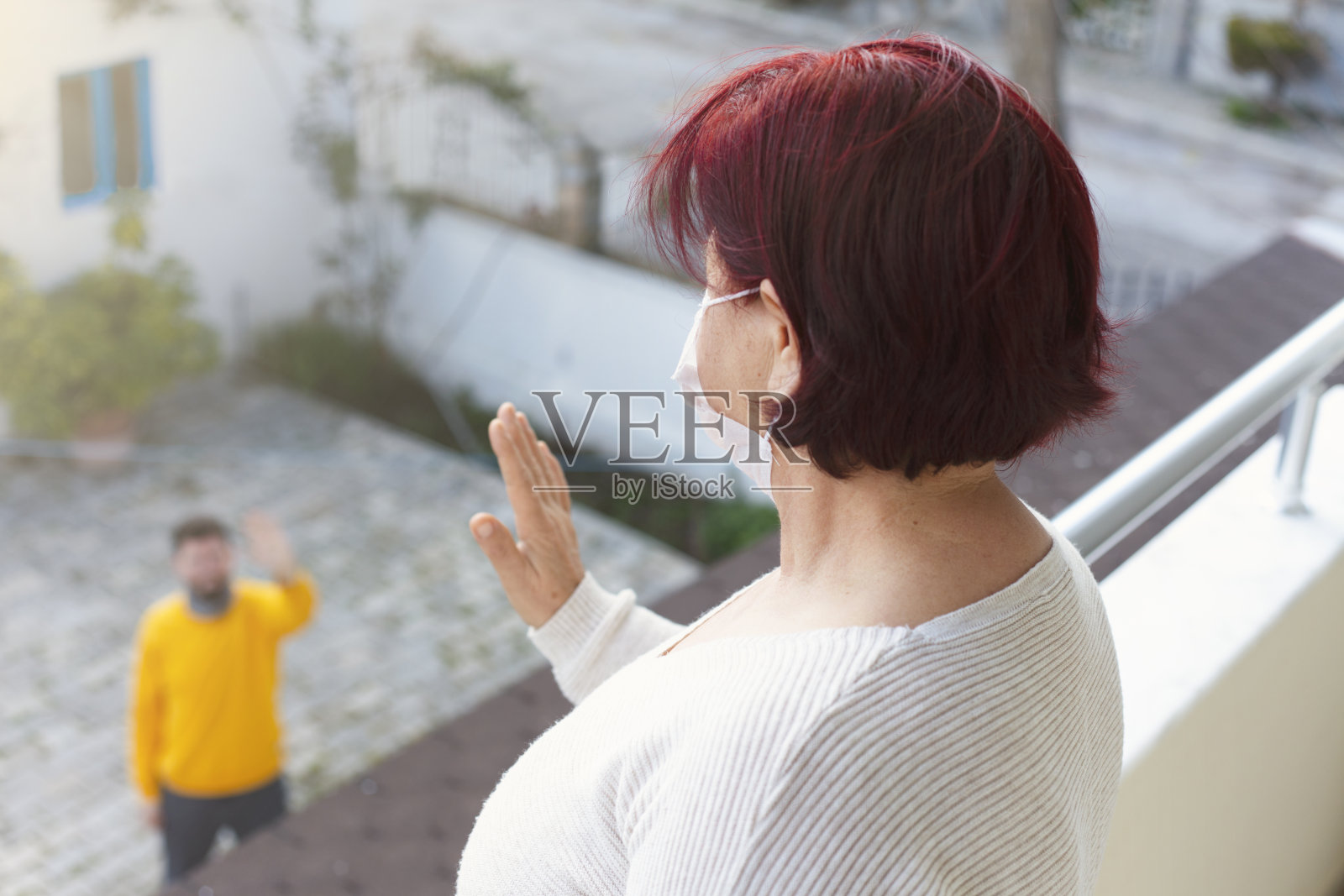 老女人的手。从远方向你的孩子问好。被隔离的老妇人远远地看着她的亲人。照片摄影图片