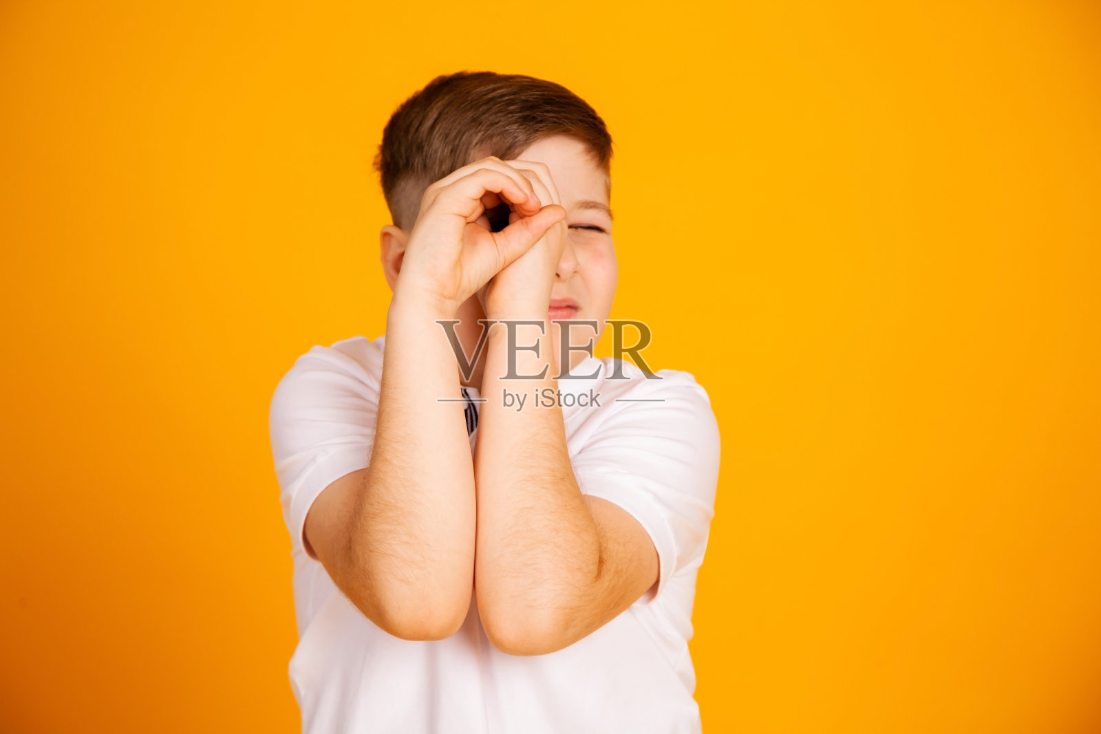 这个男孩看起来像用双筒望远镜。双手照片摄影图片