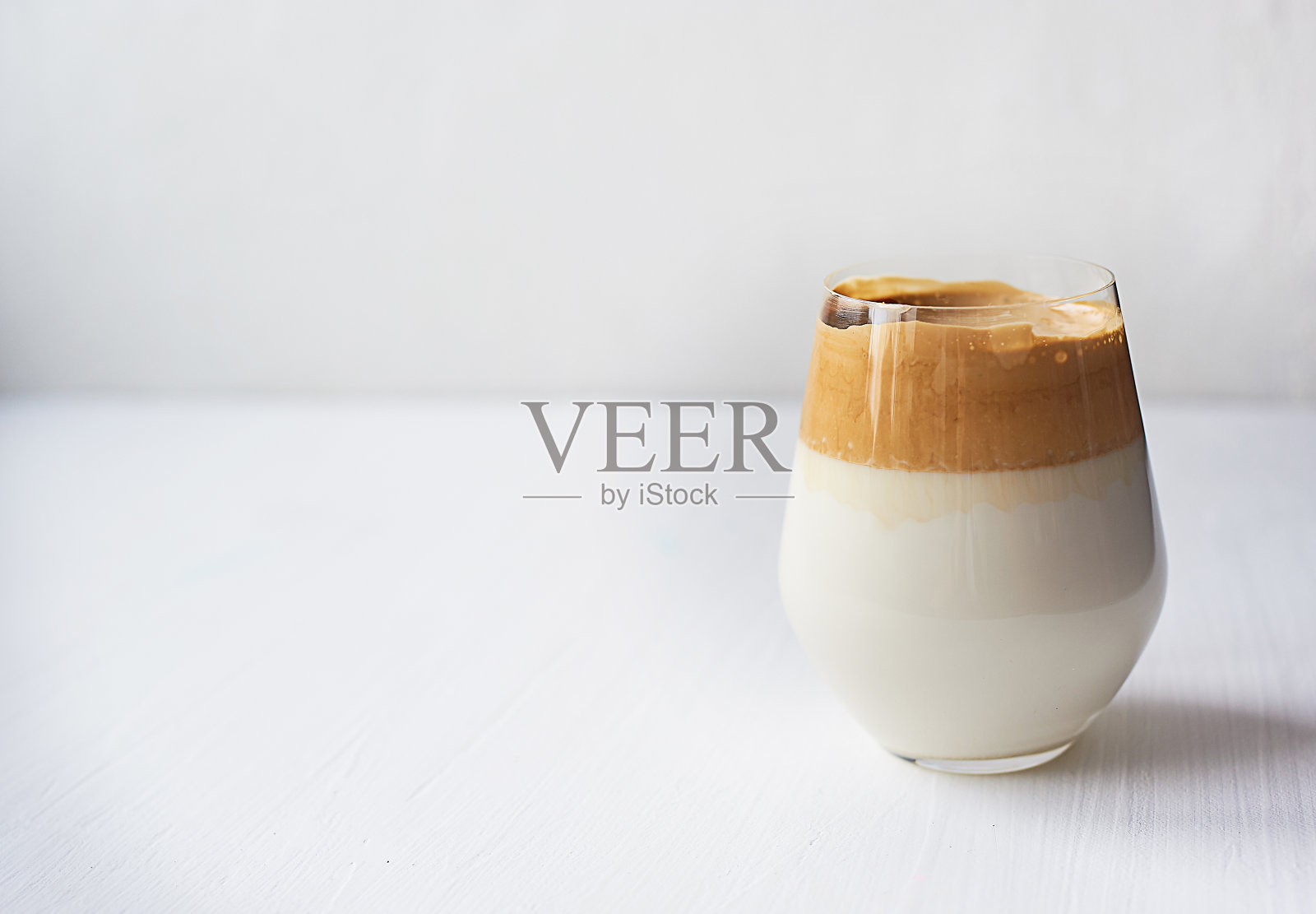 冷咖啡奶油加冷达尔贡牛奶。的趋势。在白色背景的透明玻璃上照片摄影图片