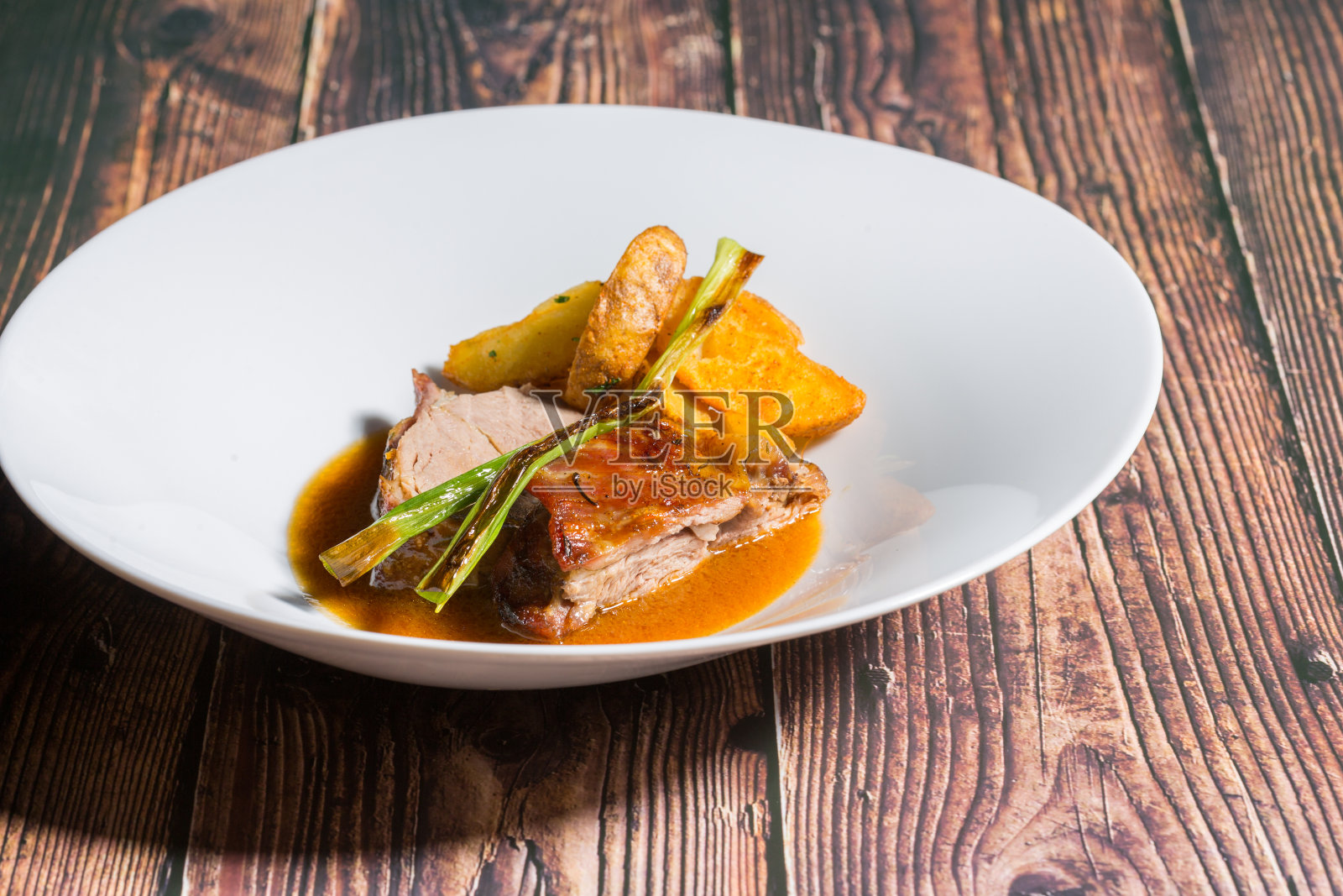 烤小牛肉和炸土豆放在餐馆的桌子上照片摄影图片