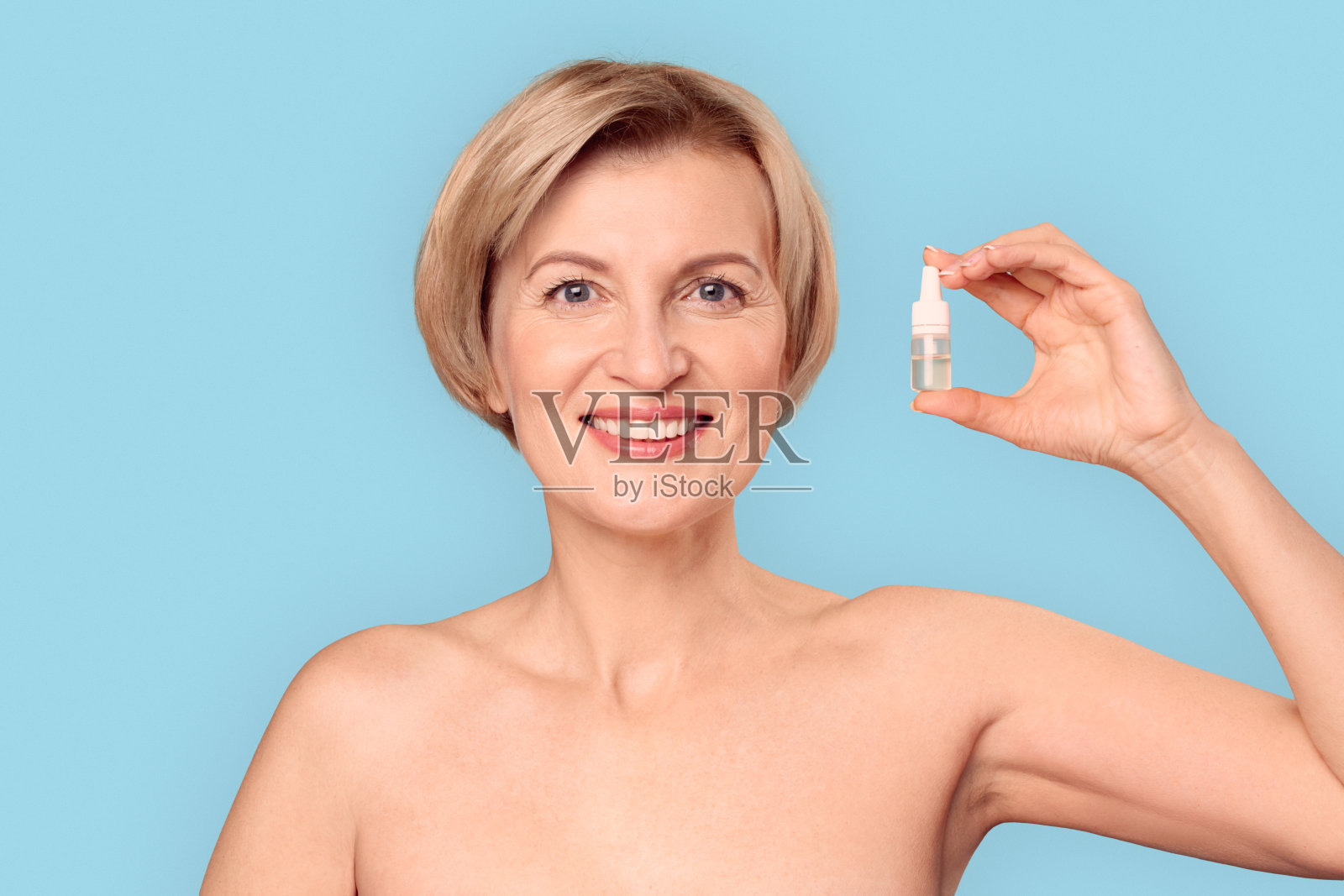 中年女性持眼药水瓶照片摄影图片