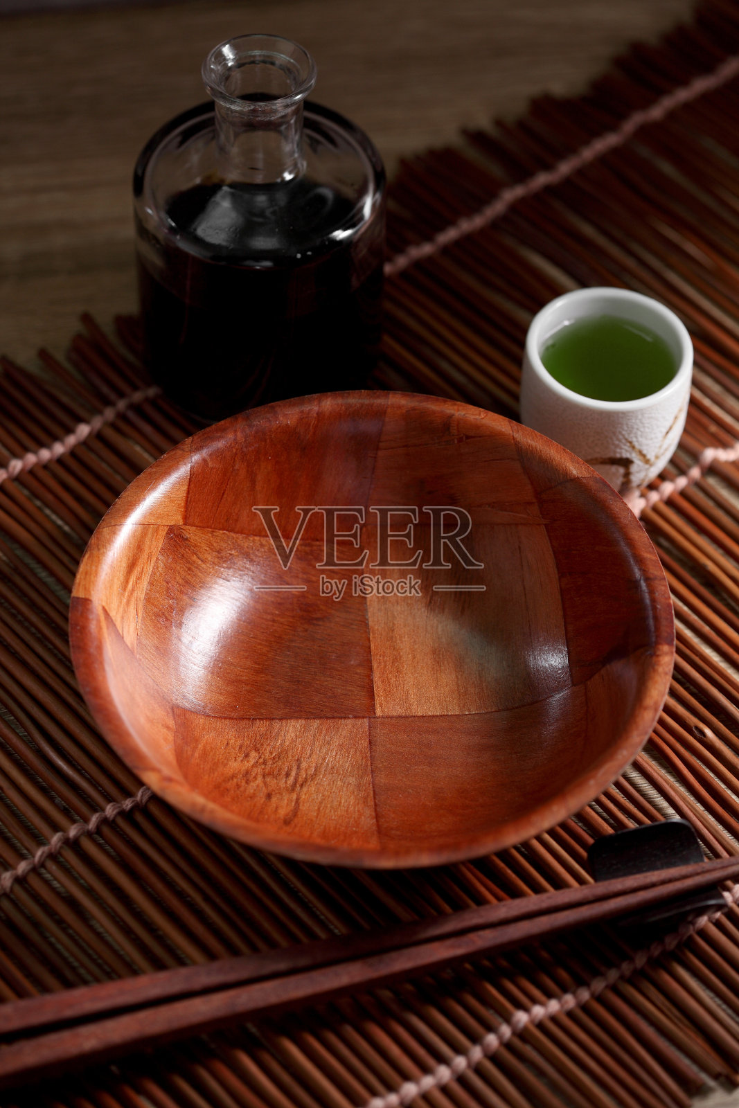 木桌上放着筷子和茶杯，配上绿茶，乡土背景下的日本器具照片摄影图片