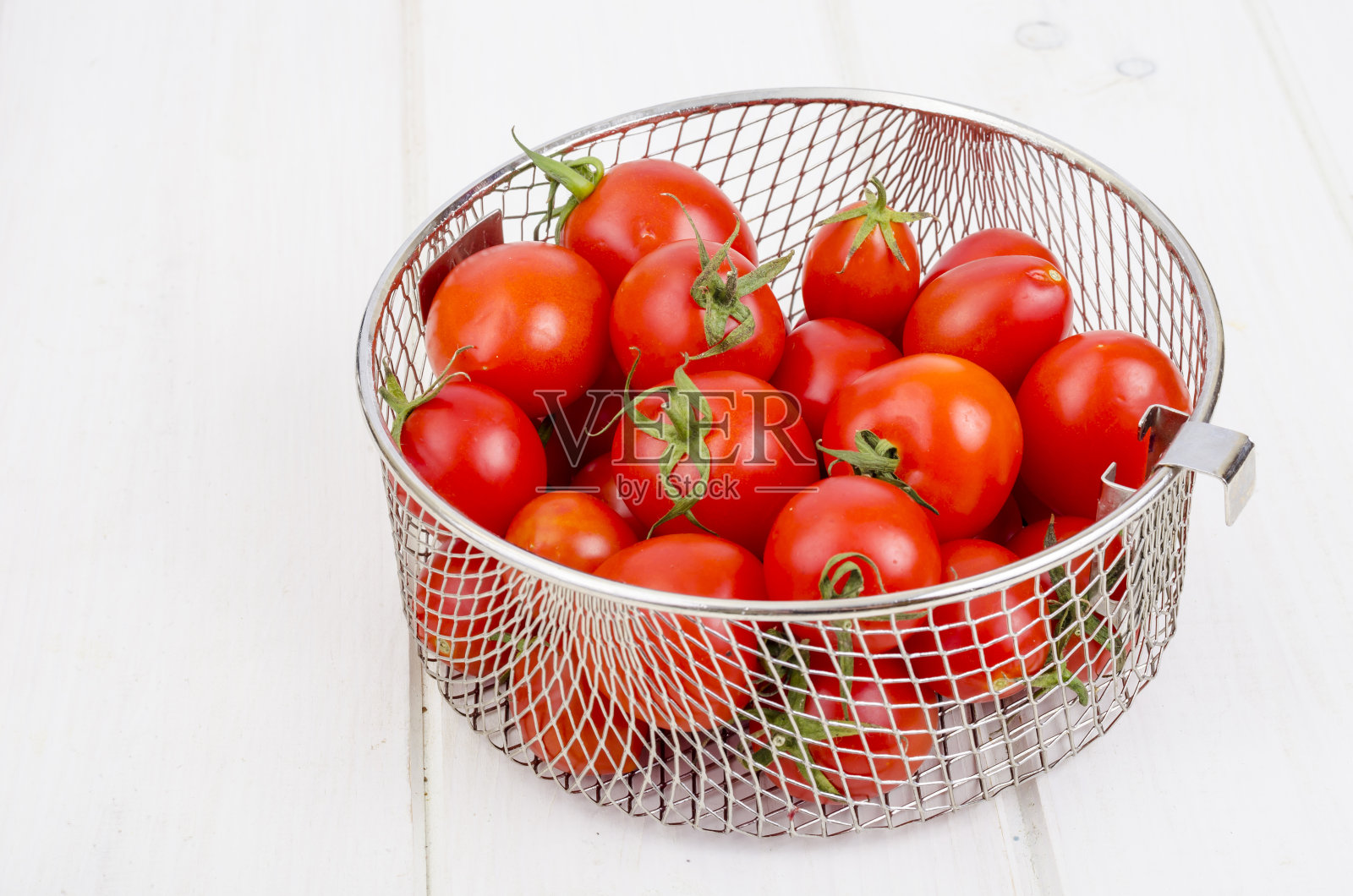 木桌上放着成熟的红樱桃番茄。照片摄影图片