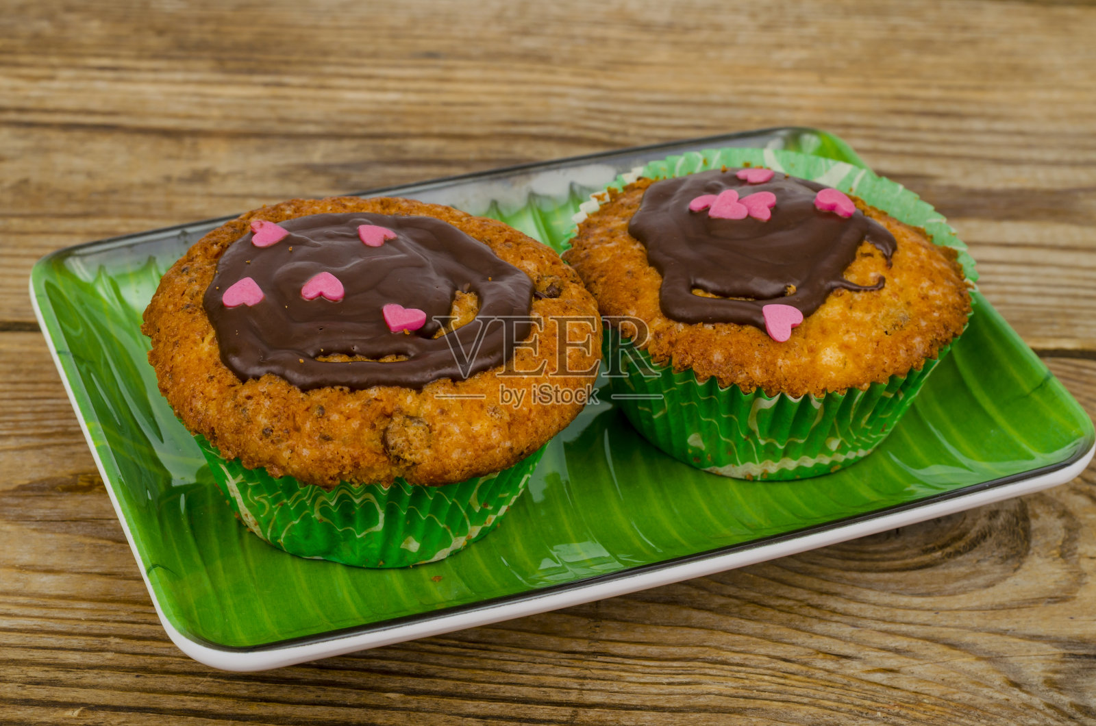 自制的蛋糕。两个美味的香草甜松饼和巧克力糖霜。照片摄影图片