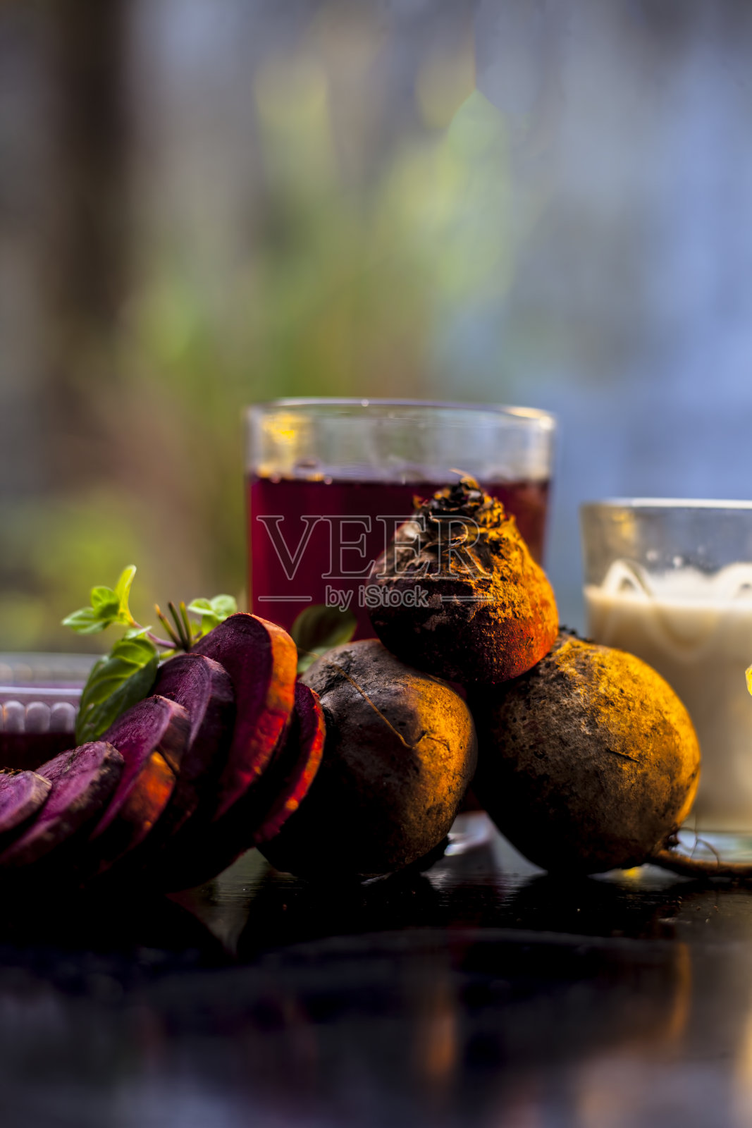 甜菜根面膜，用一些甜菜根汁与牛奶和蜂蜜混合均匀制成的黑色光滑表面。用于干性皮肤的水疗。垂直拍摄的甜菜根面膜在一个木制的表面。照片摄影图片