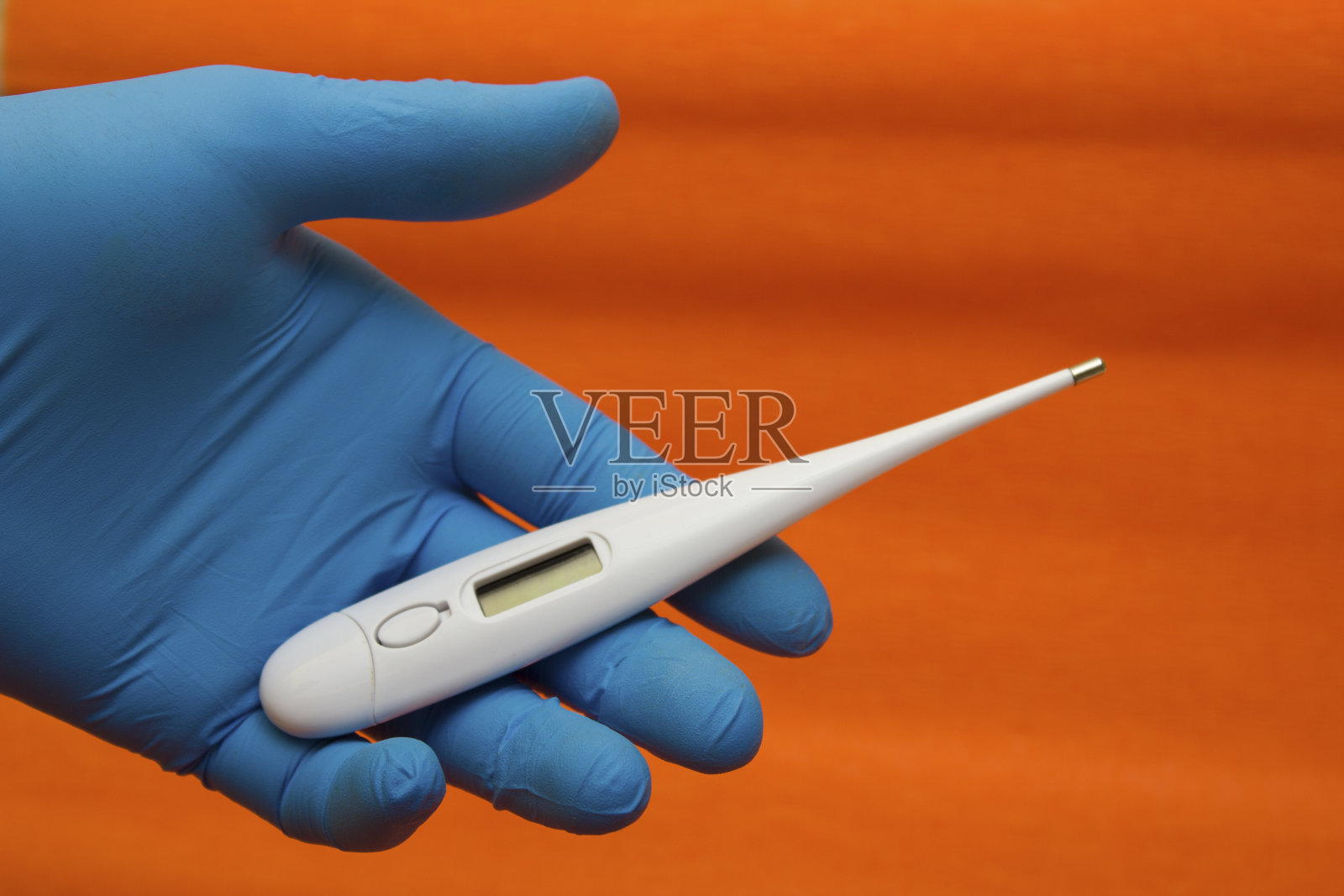 手持医用手套，装有电子温度计——温度测量、冠状病毒、新冠病毒照片摄影图片