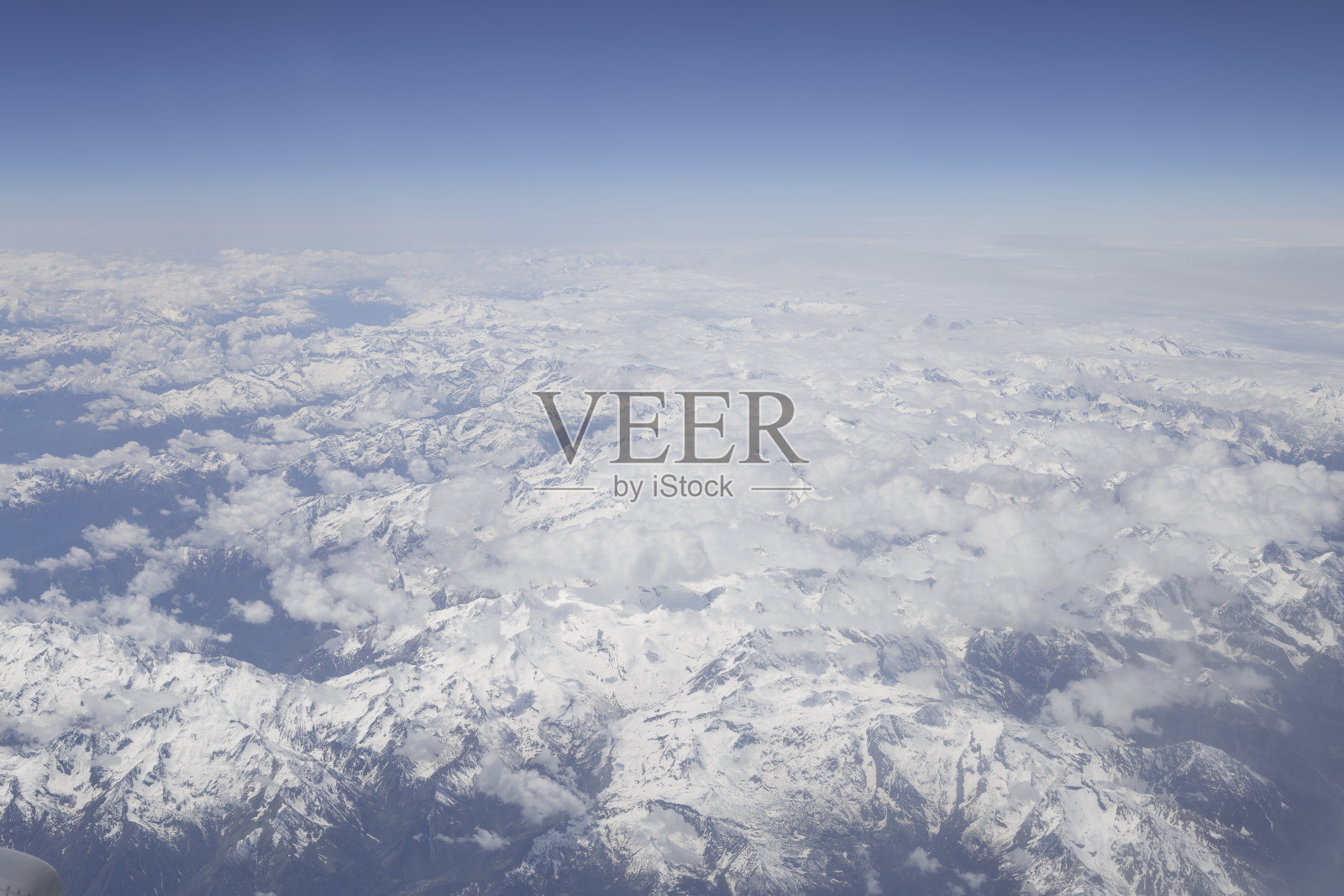 一架商用飞机在阿尔卑斯山上空的航拍。照片摄影图片