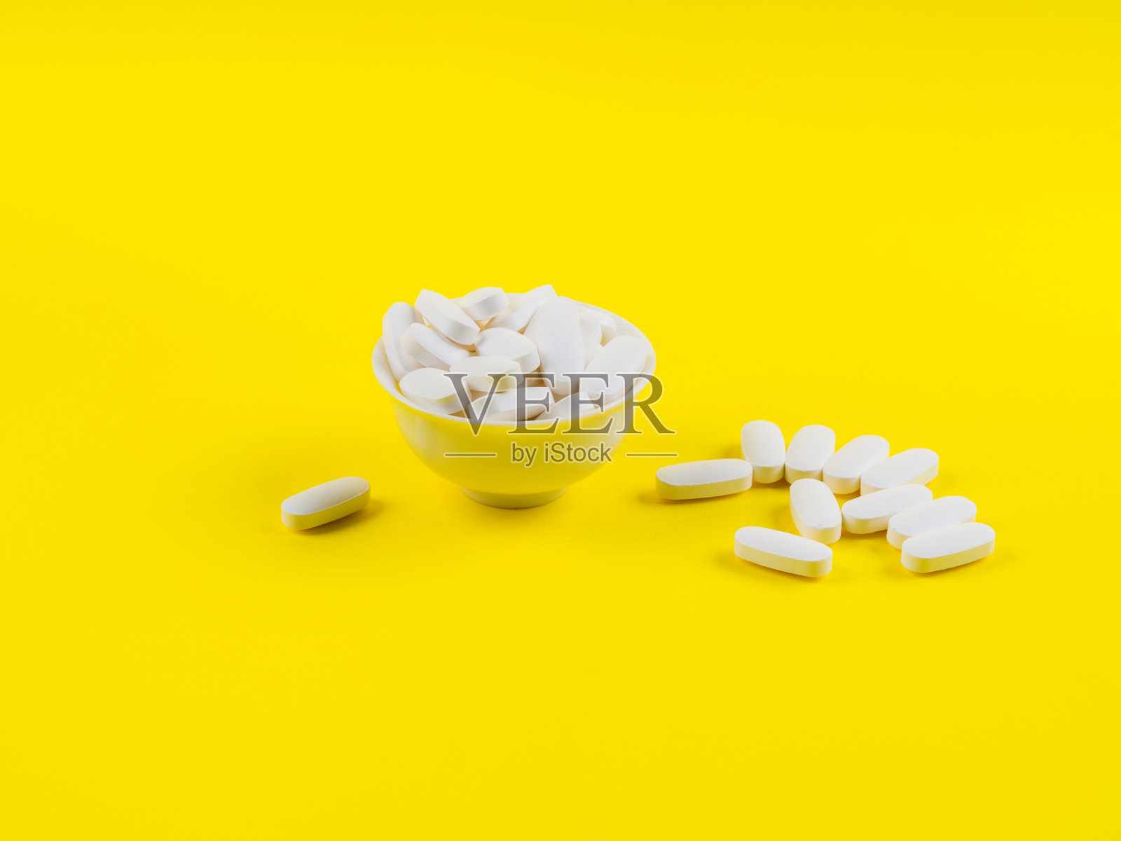白色柠檬酸镁药丸，黄色背景照片摄影图片