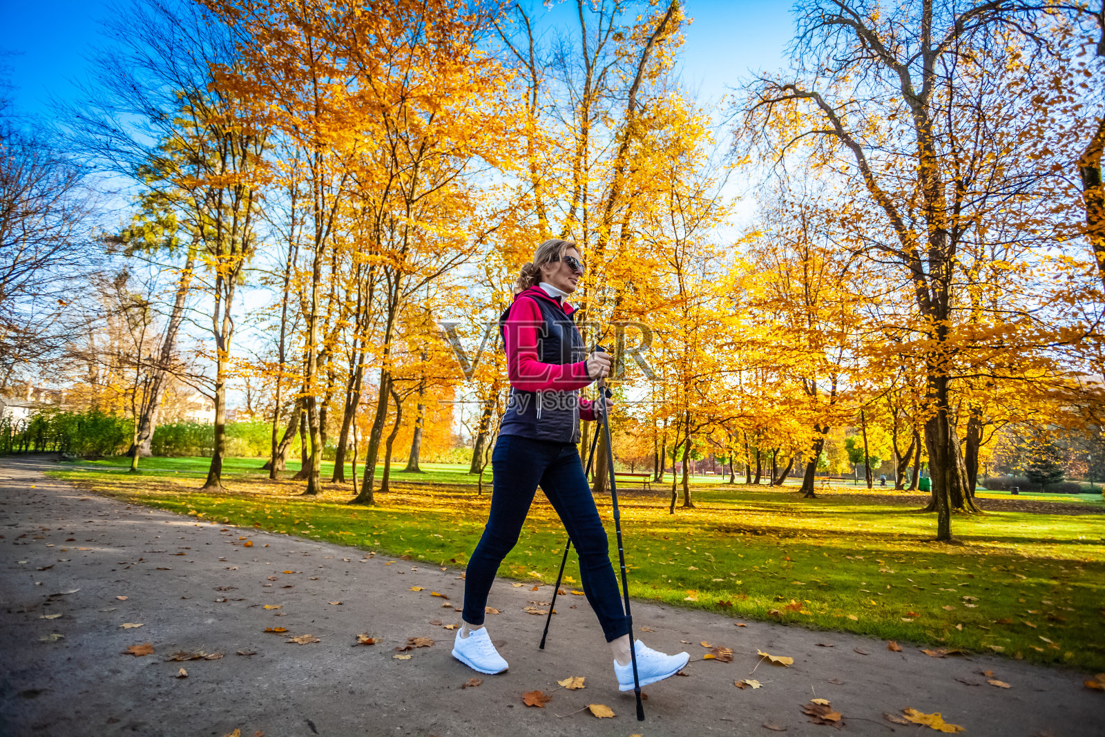 中年妇女北欧行走在城市公园照片摄影图片