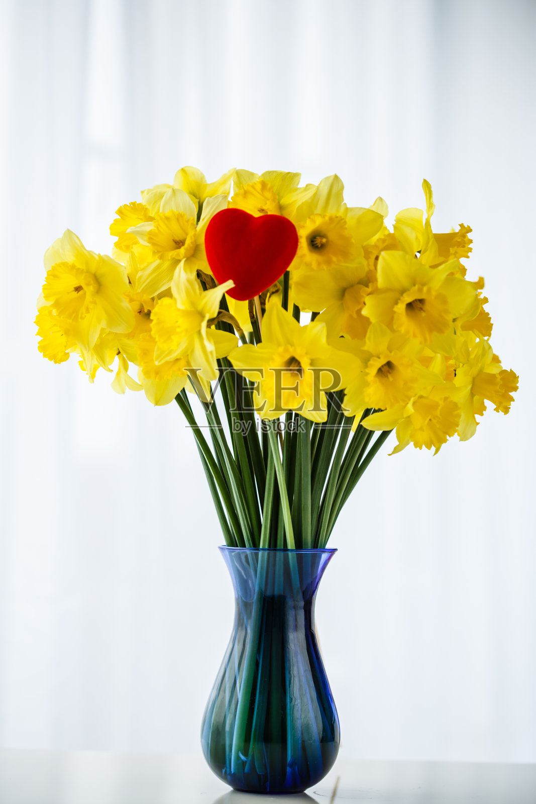 蓝色花瓶里的一束黄水仙照片摄影图片