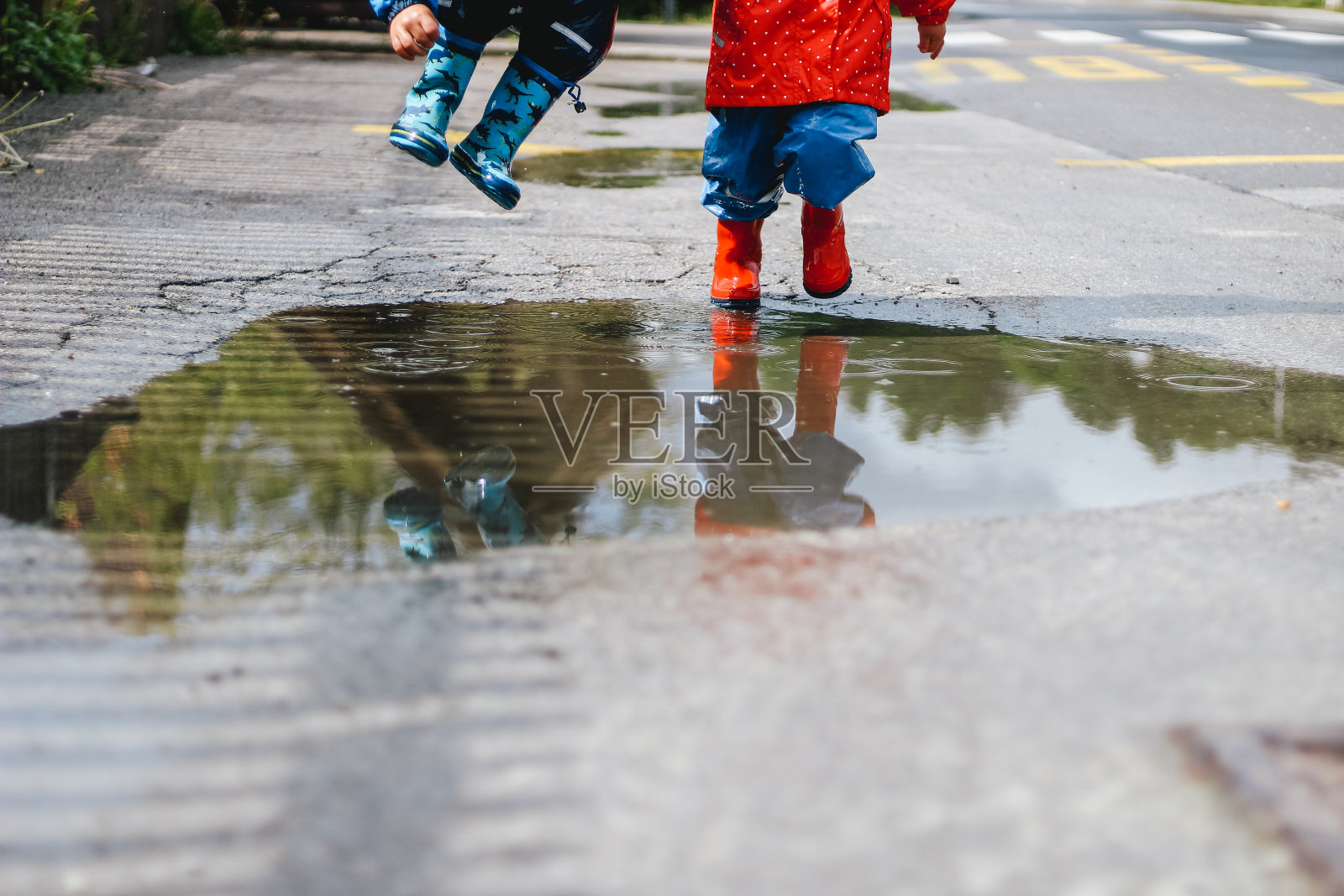 孩子们在水坑里玩耍照片摄影图片