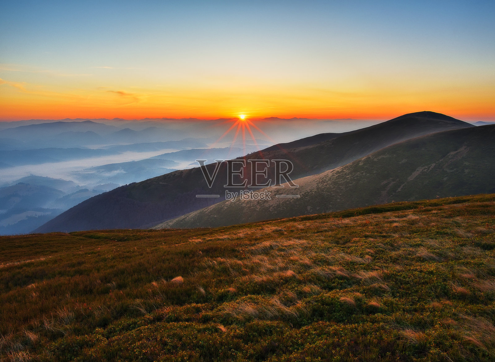 雾山的剪影。日出时风景如画的山峰。照片摄影图片