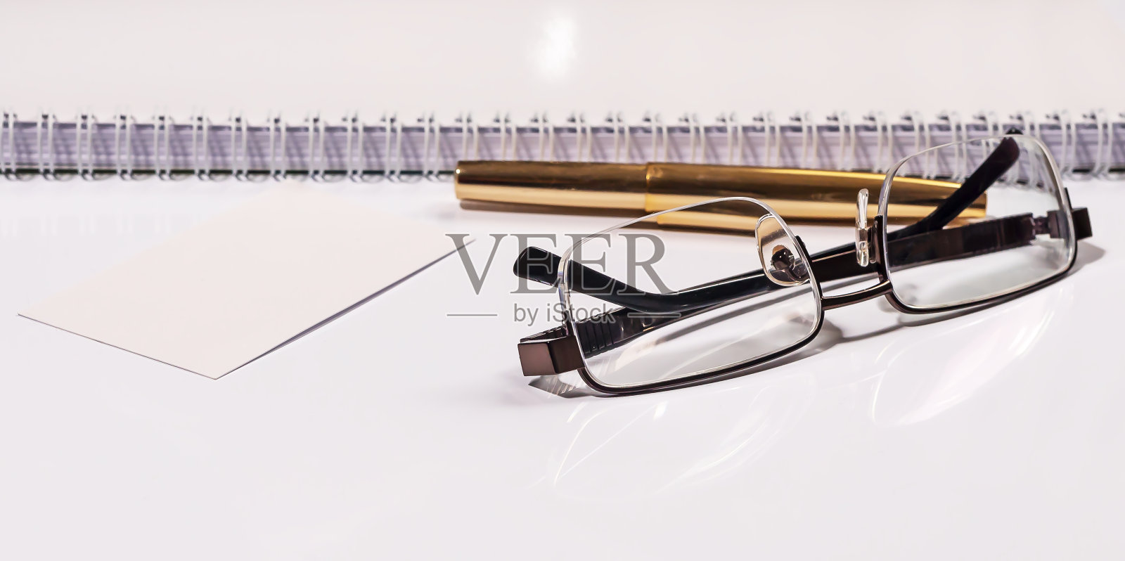 金色的钢笔、笔记本和眼镜在黑白和金色的构图中。经营理念照片摄影图片