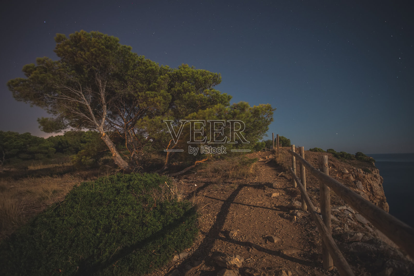 西班牙布拉瓦海岸的夜晚景观，月亮升起和岩石海岸照片摄影图片