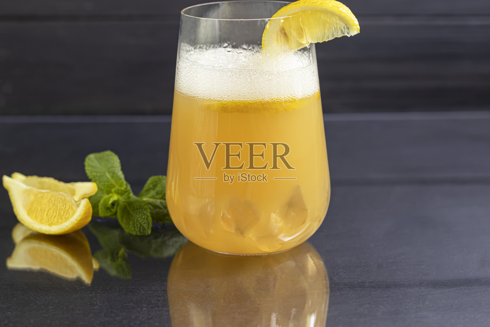 新鲜的自制姜汁啤酒鸡尾酒。桌上有冰和酸橙。在黑色的背景上。本空间照片摄影图片