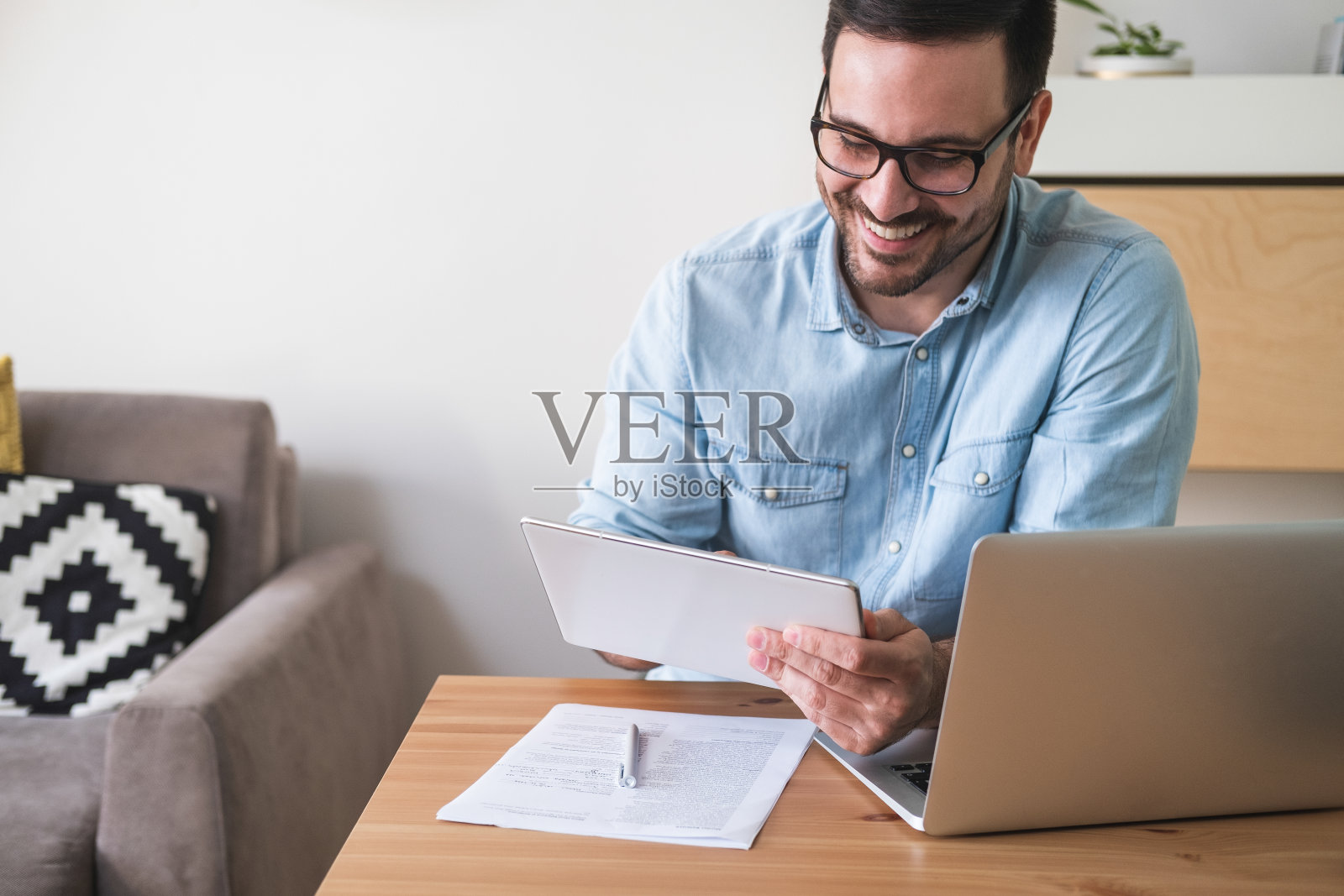 英俊微笑的男人看数字平板电脑库存照片照片摄影图片