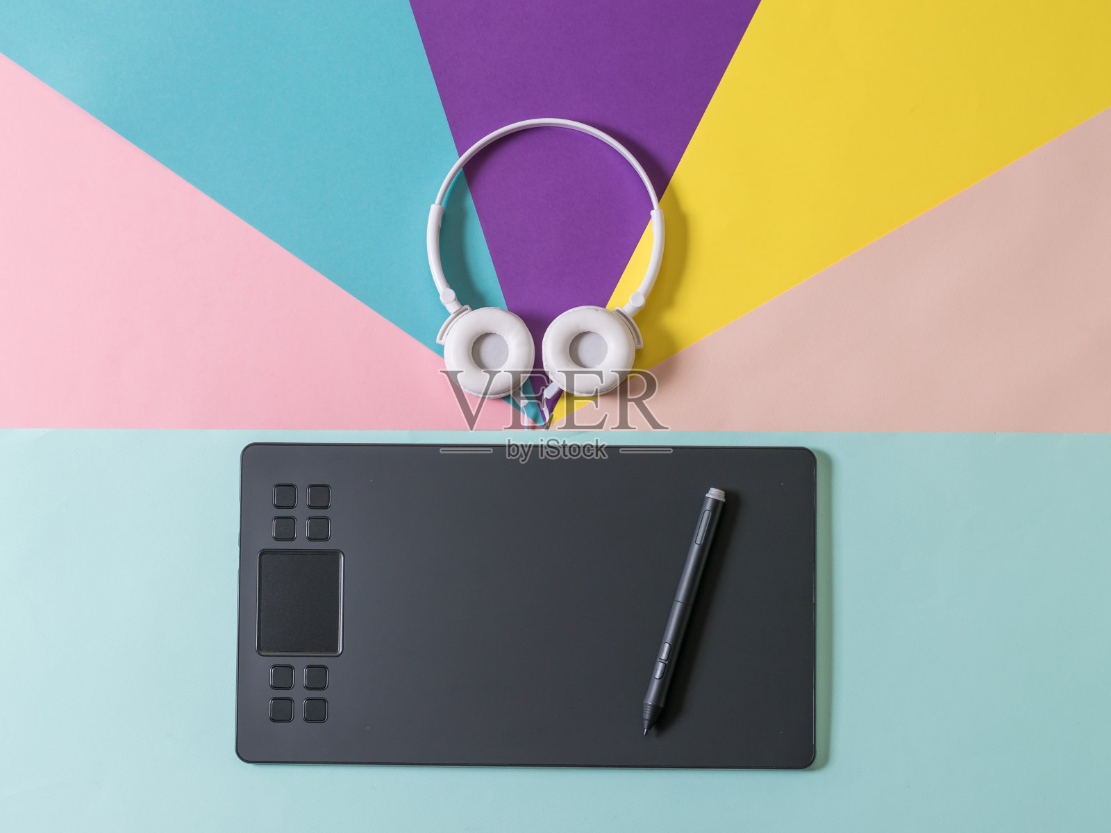 彩色背景的耳机和蓝色背景的图形平板电脑。照片摄影图片