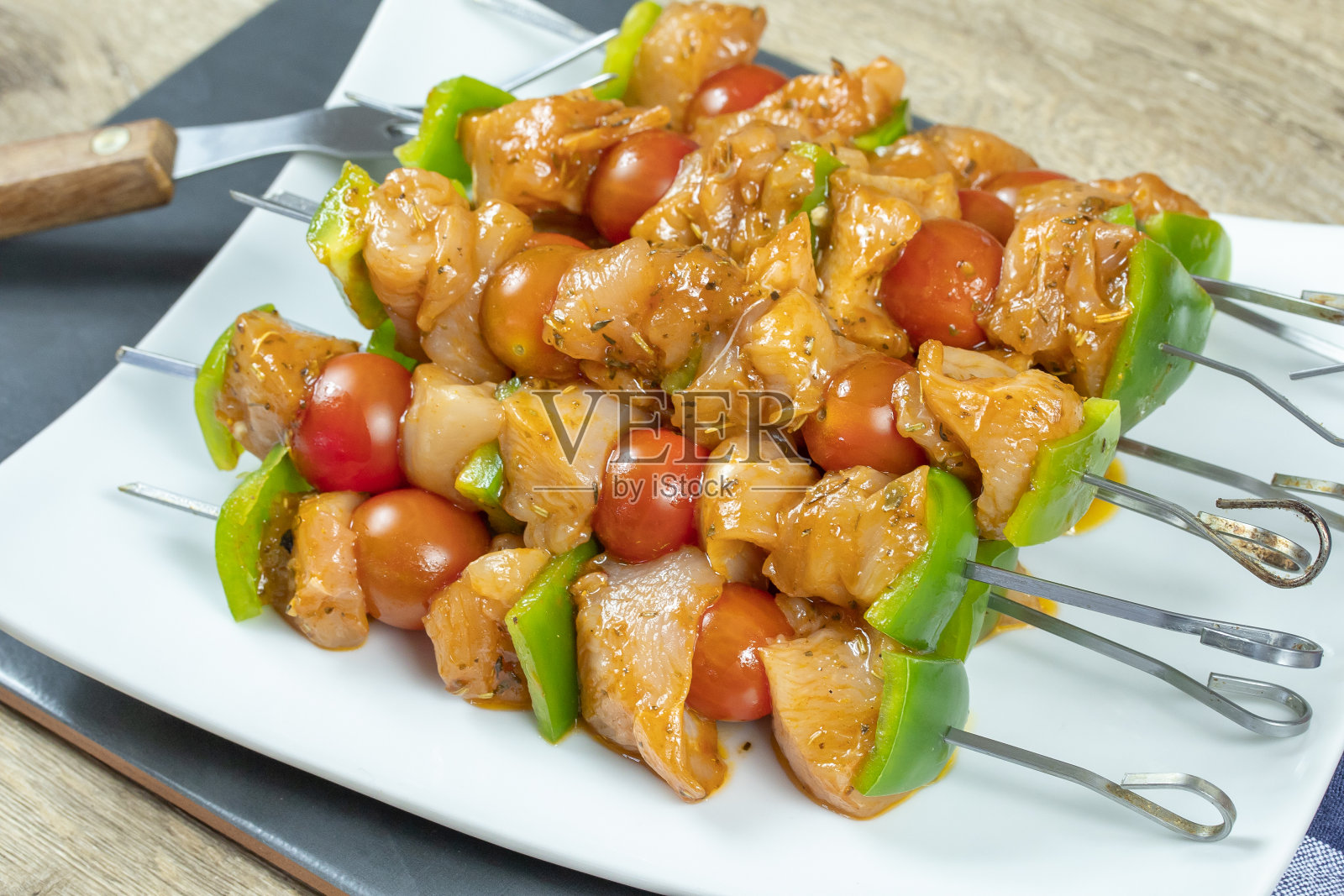 鸡串和生蔬菜放在盘子里照片摄影图片