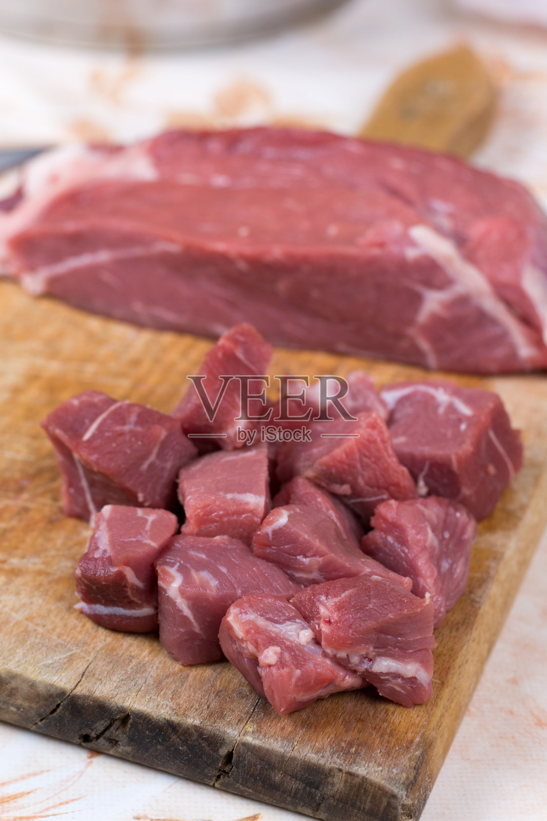 切成方块的牛排。红肉放在砧板上照片摄影图片