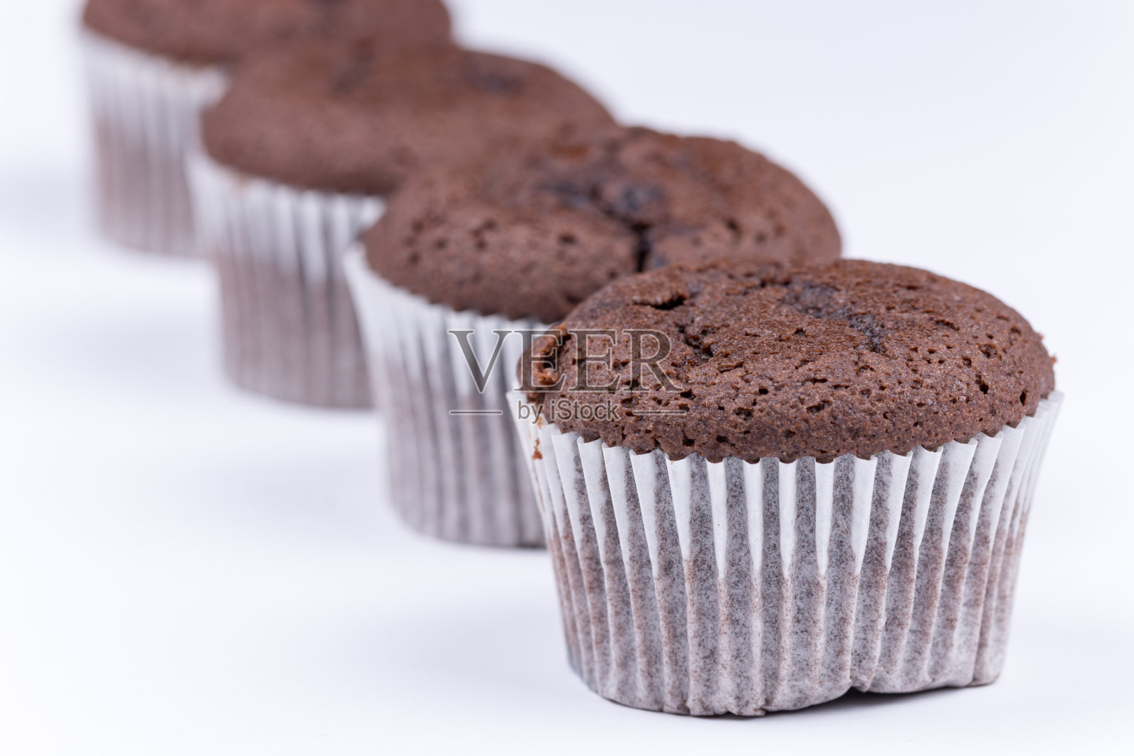 棕色的巧克力松饼排列在白色的背景上照片摄影图片