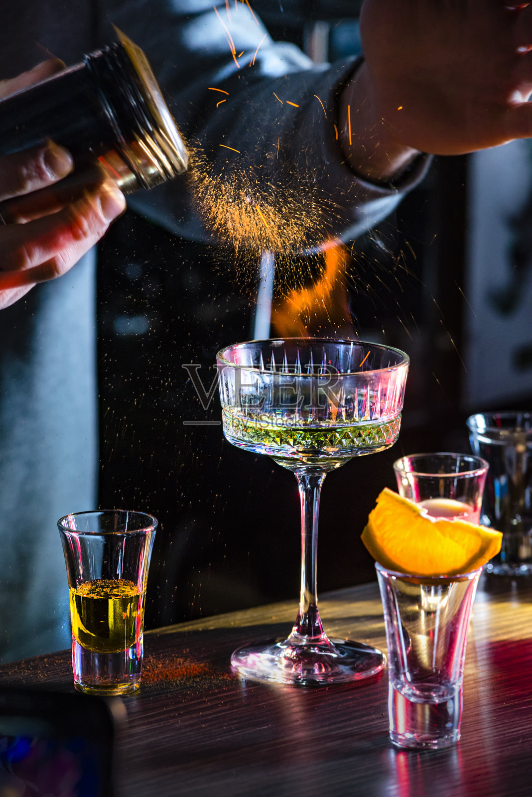 男调酒师举着火的糖上面美味的酒精鸡尾酒照片摄影图片