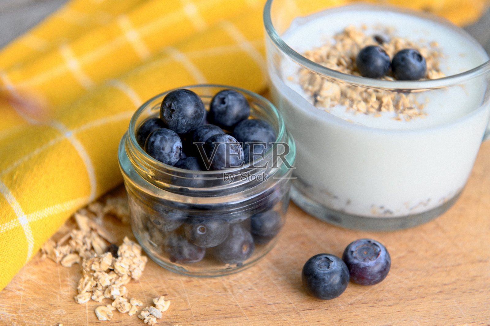 吃健康的早餐。酸奶，格兰诺拉麦片，奇亚籽，新鲜干果，透明蓝莓。清洁食品、饮食、排毒、素食理念。照片摄影图片