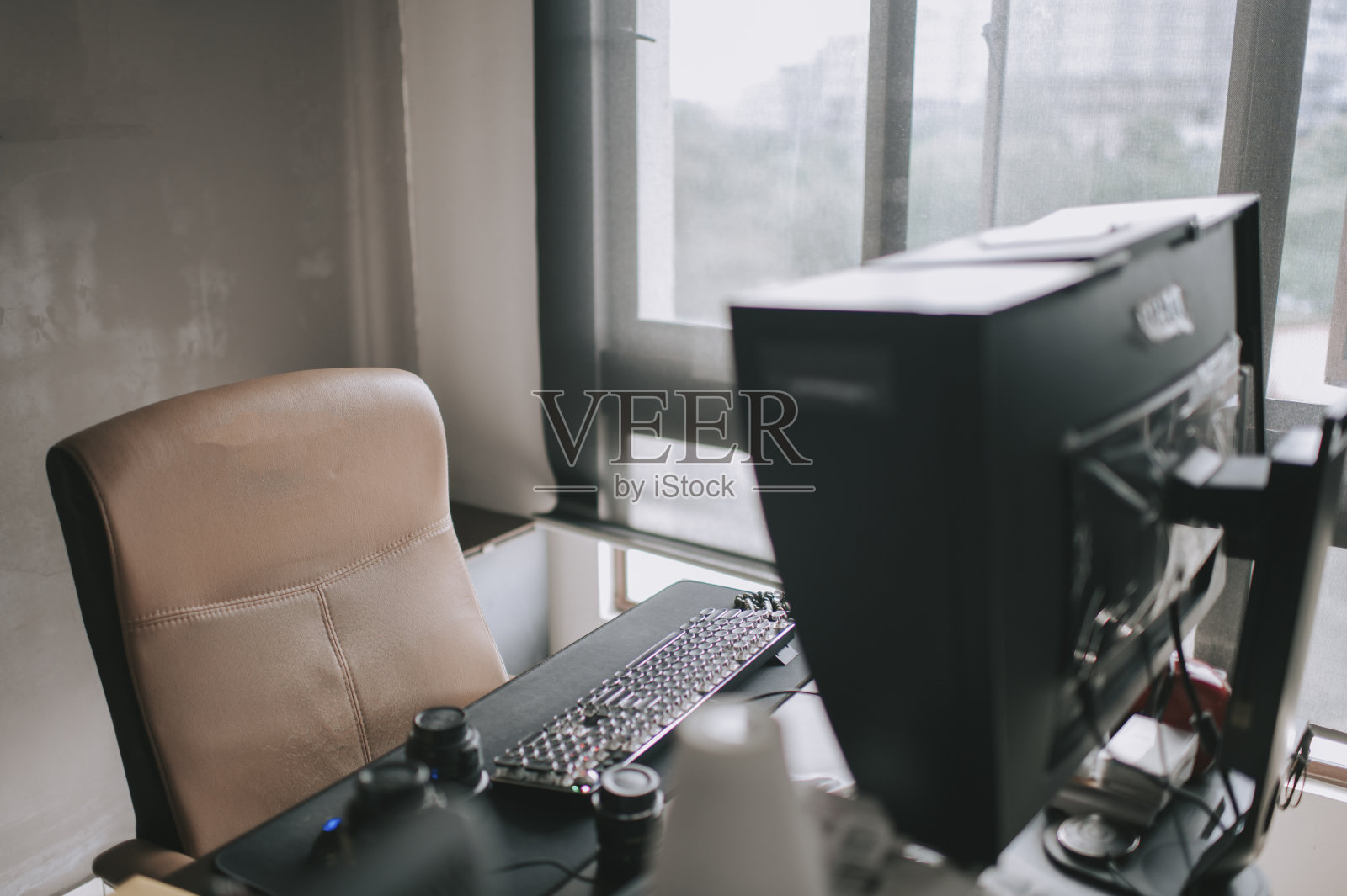 窗户附近有电脑桌面和椅子的家庭办公室照片摄影图片