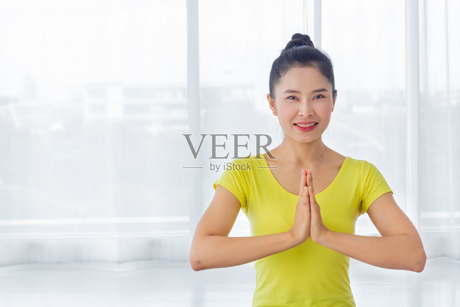 一个美丽的亚洲女人在瑜伽房里练习瑜伽，以保持身体健康和肌肉的灵活性，并感到良好和幸福。这是一种对每个人都有益的生活方式活动。照片摄影图片