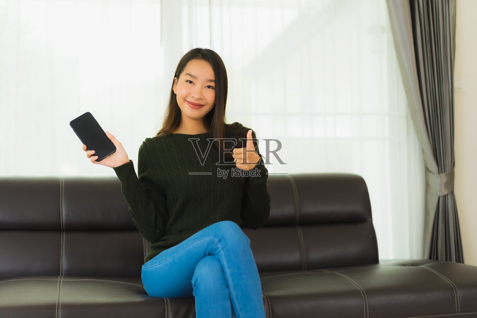 肖像美丽的年轻亚洲妇女使用智能手机或手机照片摄影图片