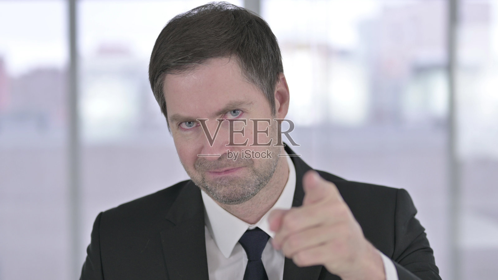 中年商人指着相机的肖像照片摄影图片