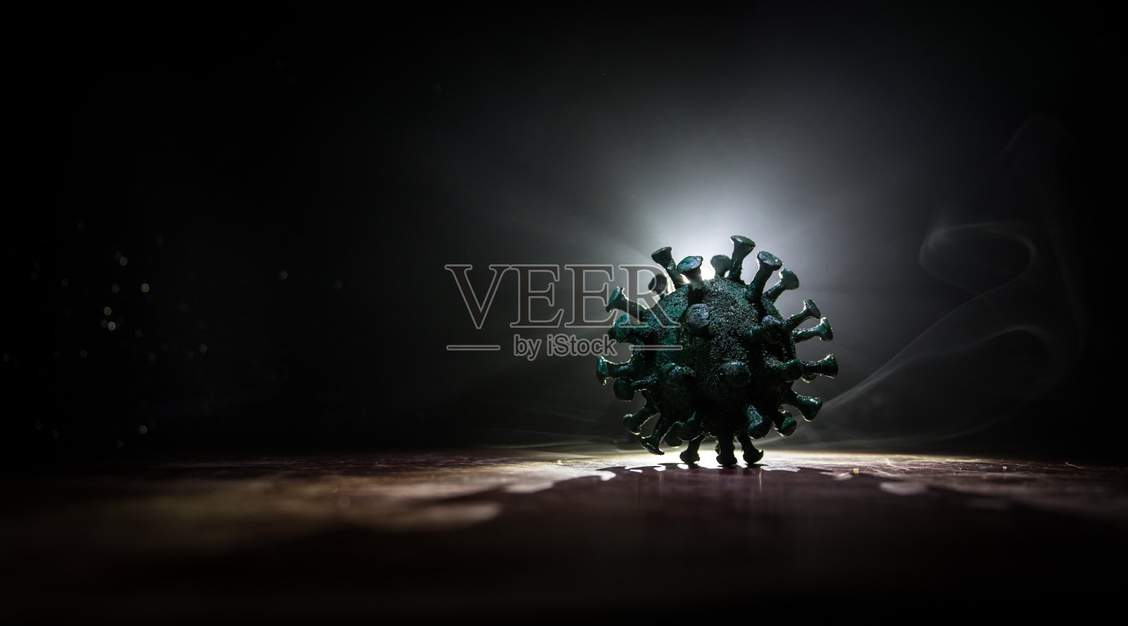 冠状病毒2019-nCov新型冠状病毒概念。木制桌子上有雾和背光的大型冠状病毒模型。创意艺术品装饰。照片摄影图片