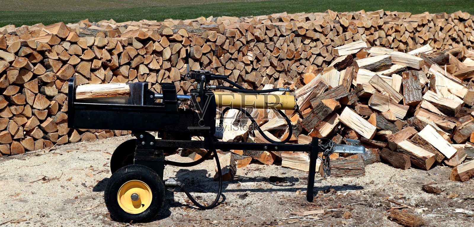 劈柴机后面堆满了木头照片摄影图片