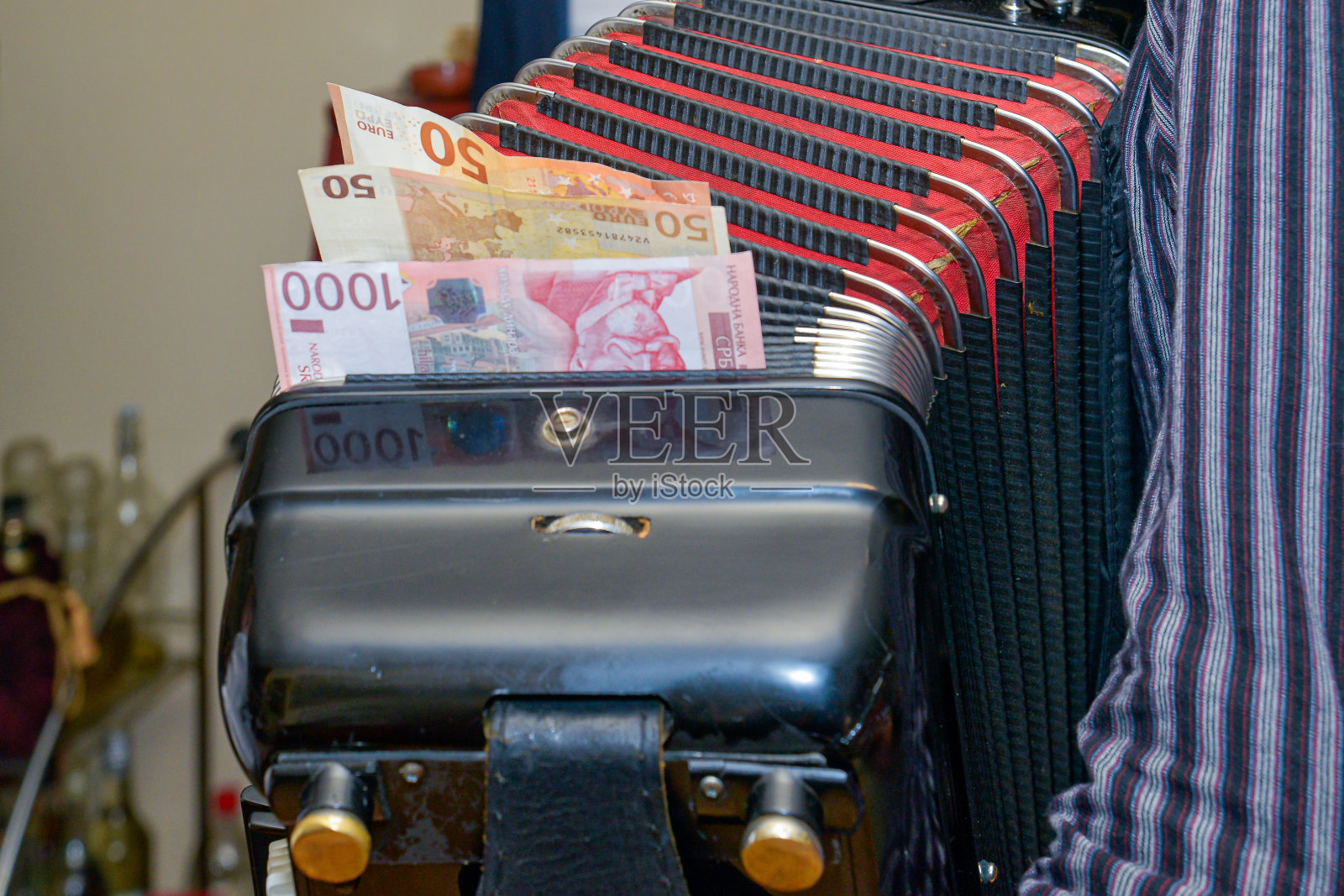 钱夹在手风琴的顶部特写。混合洗礼仪式。这位手风琴手的客人以金钱来表示敬意照片摄影图片