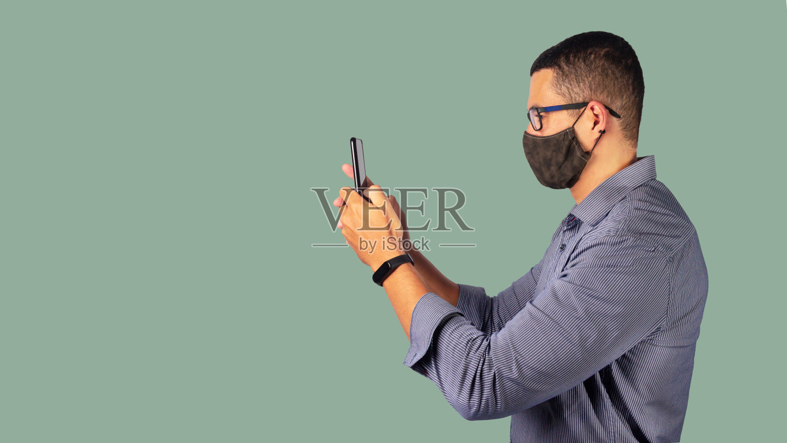 一名成年商人身穿社交t恤，戴着N95口罩，以保护自己免受新冠病毒感染。照片摄影图片