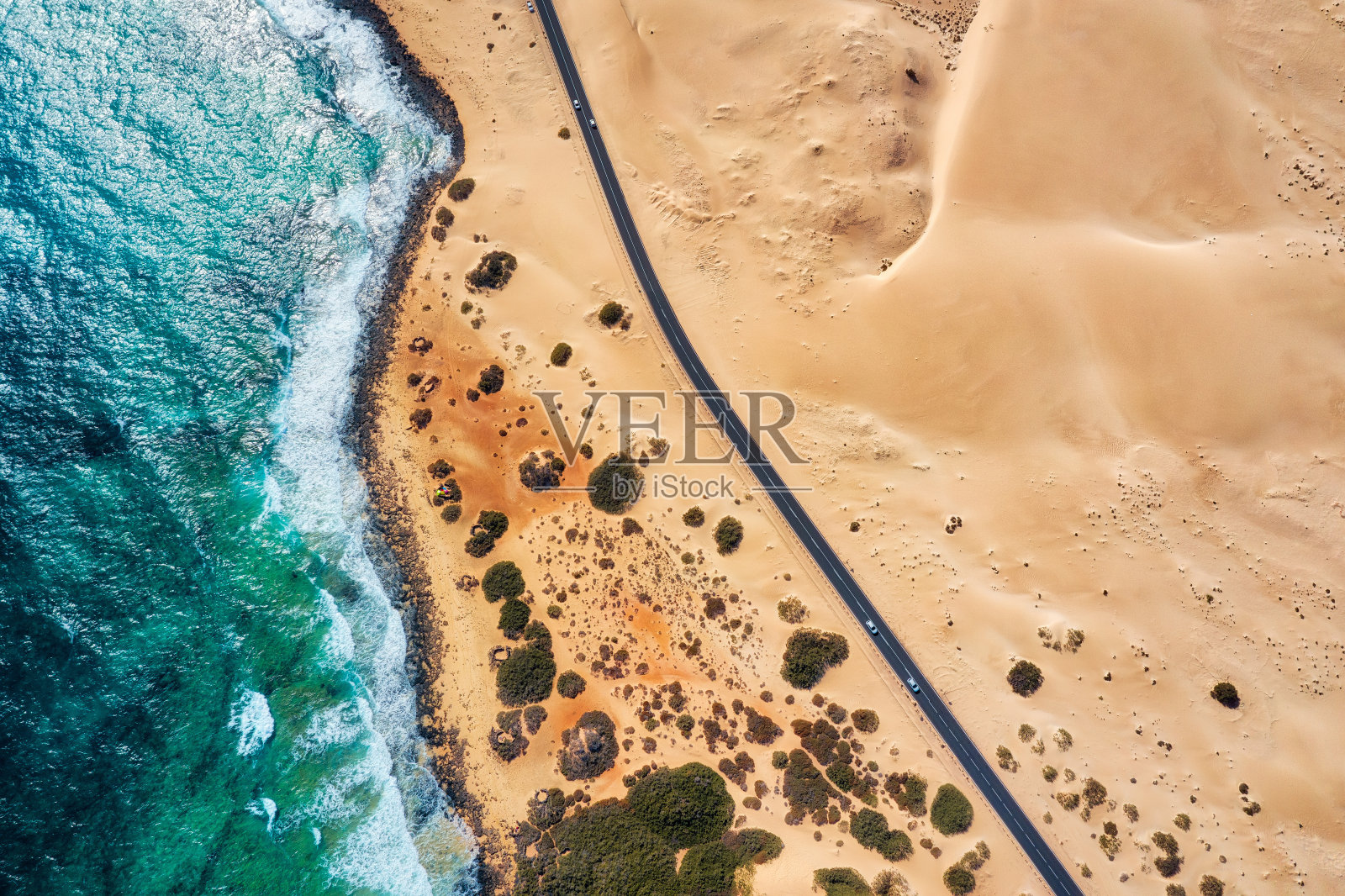 布满岩石的海岸线和高速公路，金色的沙滩和蓝色的海水照片摄影图片