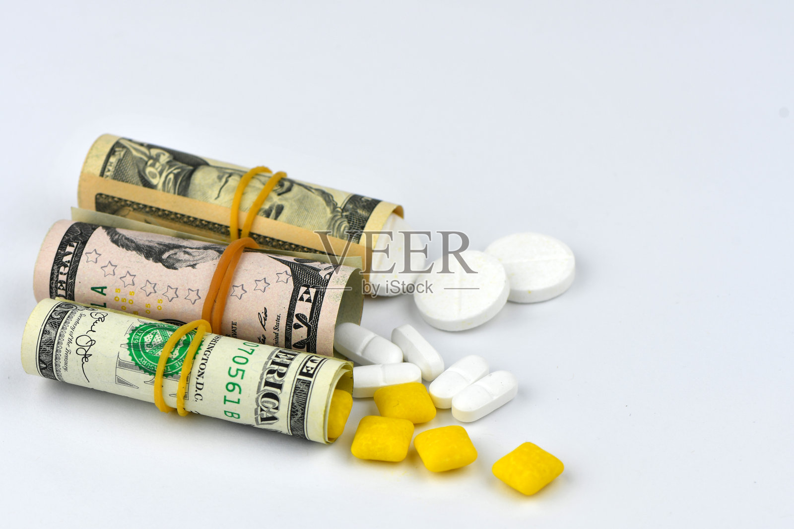 美元卷着药丸流出孤立的白色背景，高成本昂贵的药物概念。拷贝空间-映像照片摄影图片