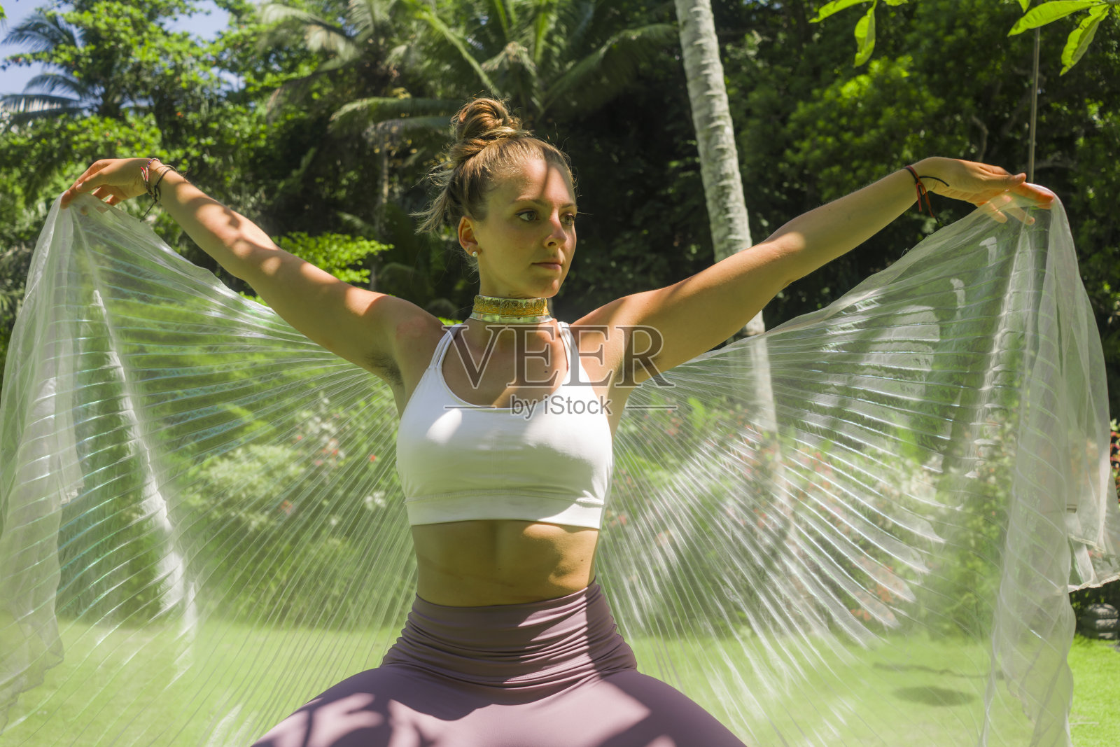 年轻美丽和快乐的女人做户外瑜伽锻炼-迷人和放松的女孩做acroyoga姿势展开翅膀布在热带雨林感觉自由照片摄影图片