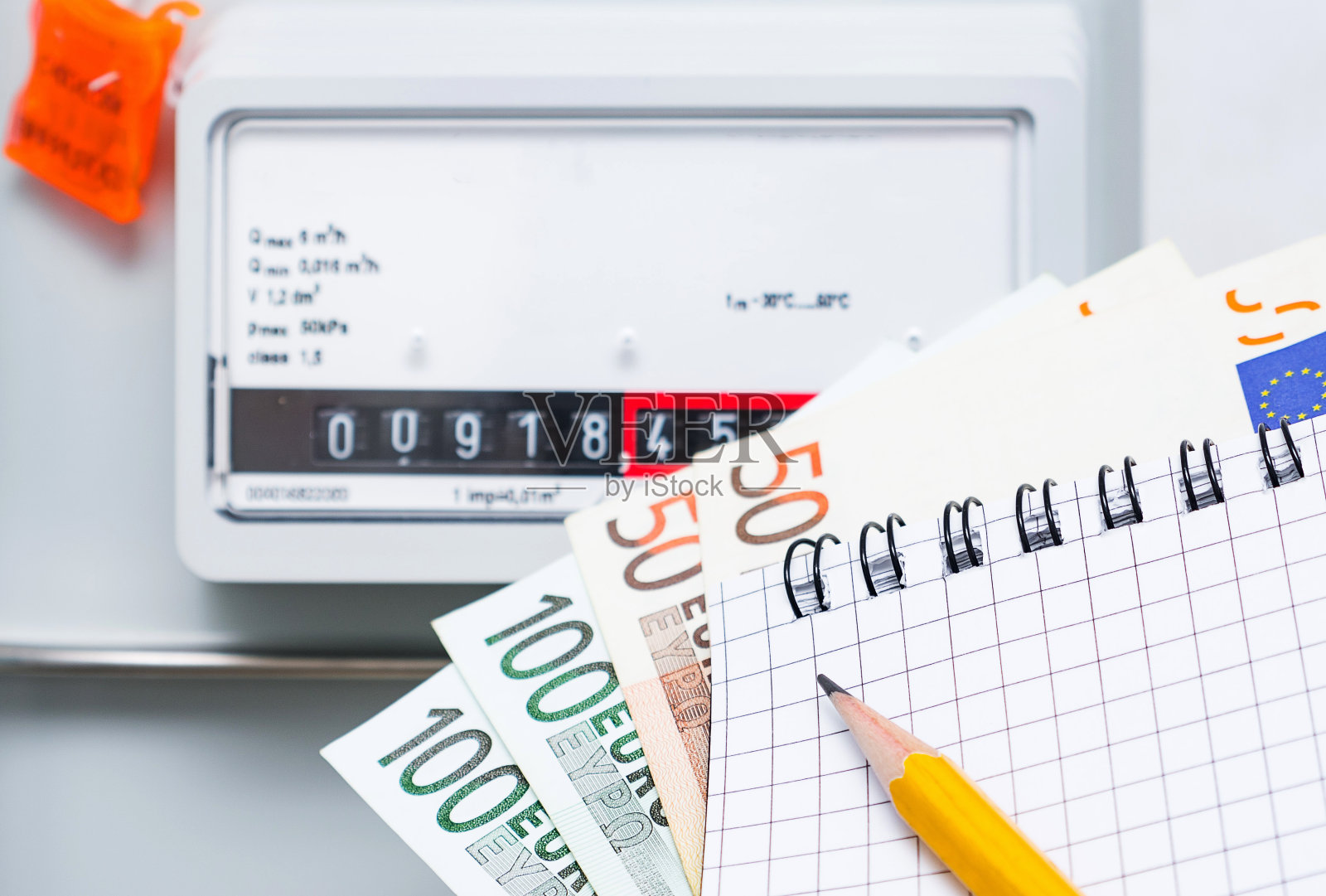 支付公用事业服务，概念形象。在煤气表的背景上有欧元钞票的笔记本照片摄影图片