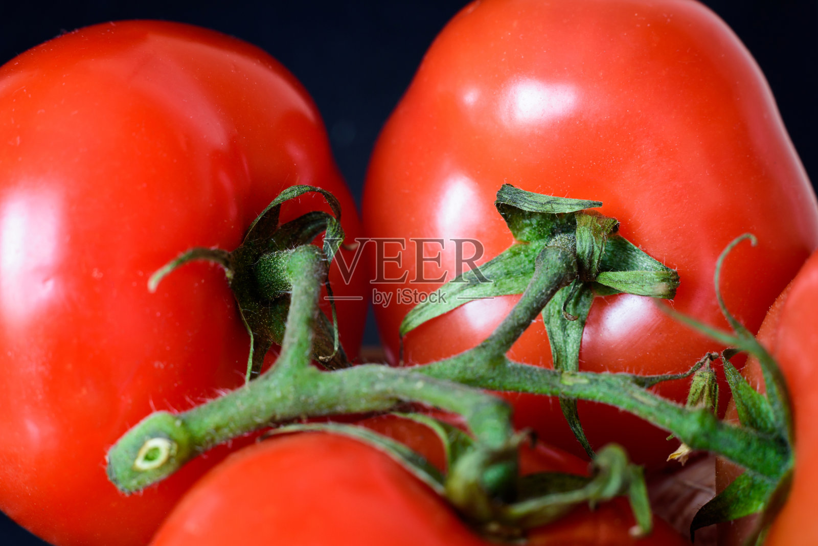 近距离观察新鲜的红色番茄，选择性聚焦。照片摄影图片