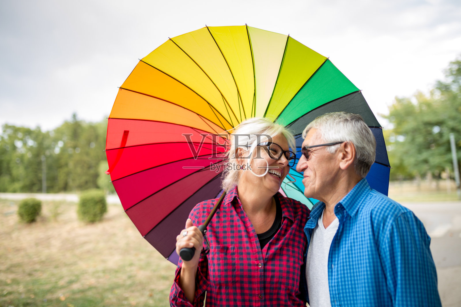 雨中打着伞的老夫妇照片摄影图片