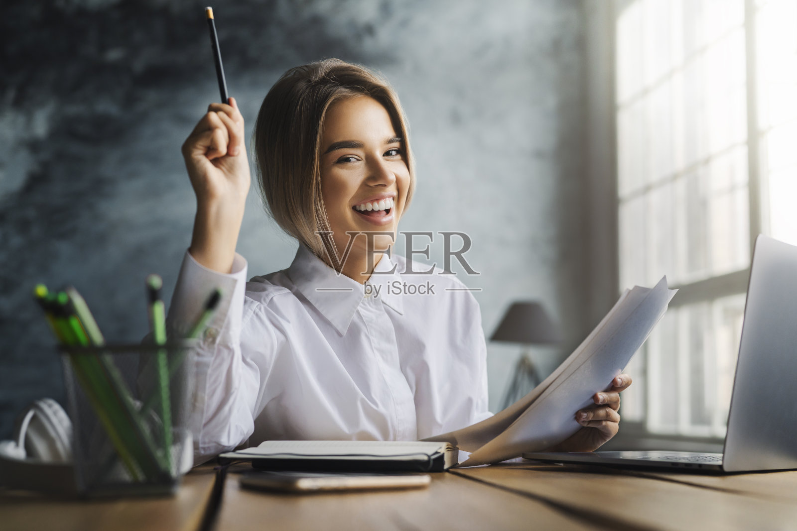 快乐的年轻女士坐在书桌前学习。准备上大学的学生。遥远的教育照片摄影图片