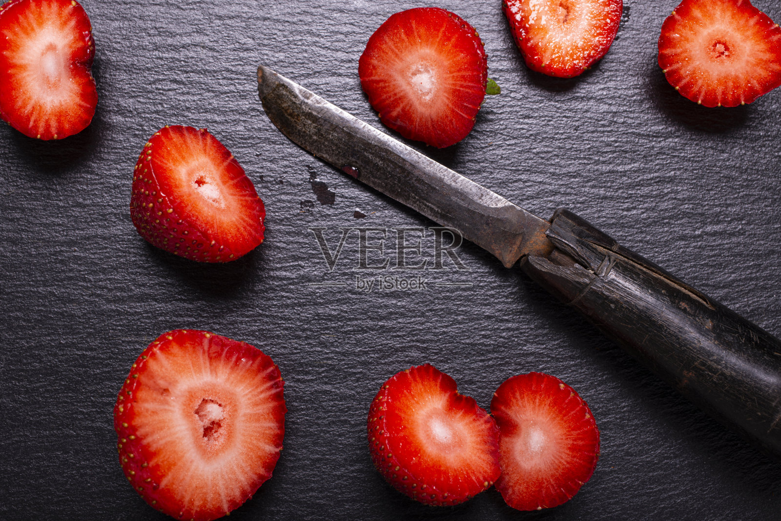 石板上有几片红草莓照片摄影图片