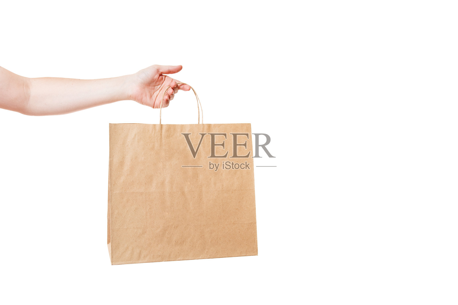 手持棕色环保工艺纸袋，标签包装杂货交付和商品孤立在白色背景与拷贝空间。照片摄影图片