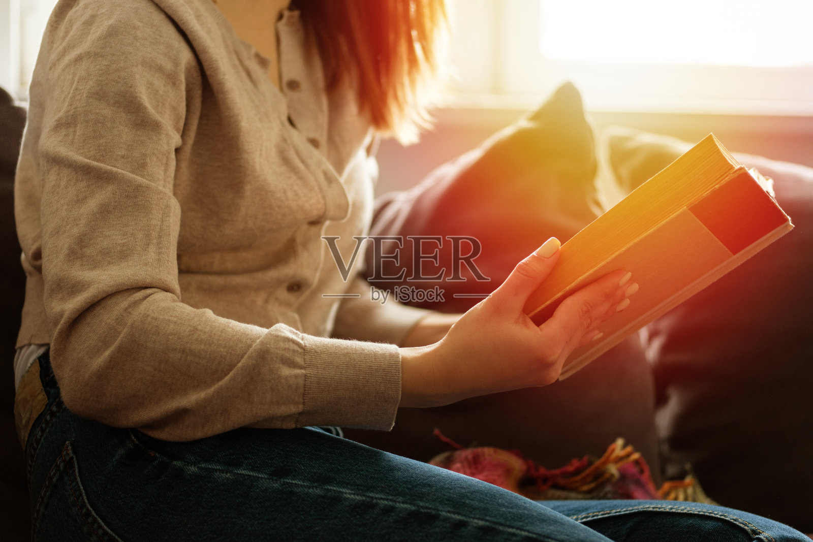 女孩正在家里的沙发上看书照片摄影图片