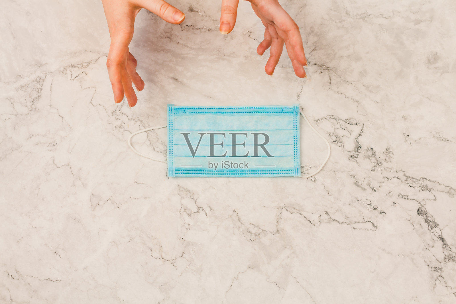 俯视图:手拿卫生口罩，预防病毒PM2.5和冠状病毒。新型冠状病毒(2019-nCoV)疫情暴发空气污染，环保意识，恐慌观念照片摄影图片